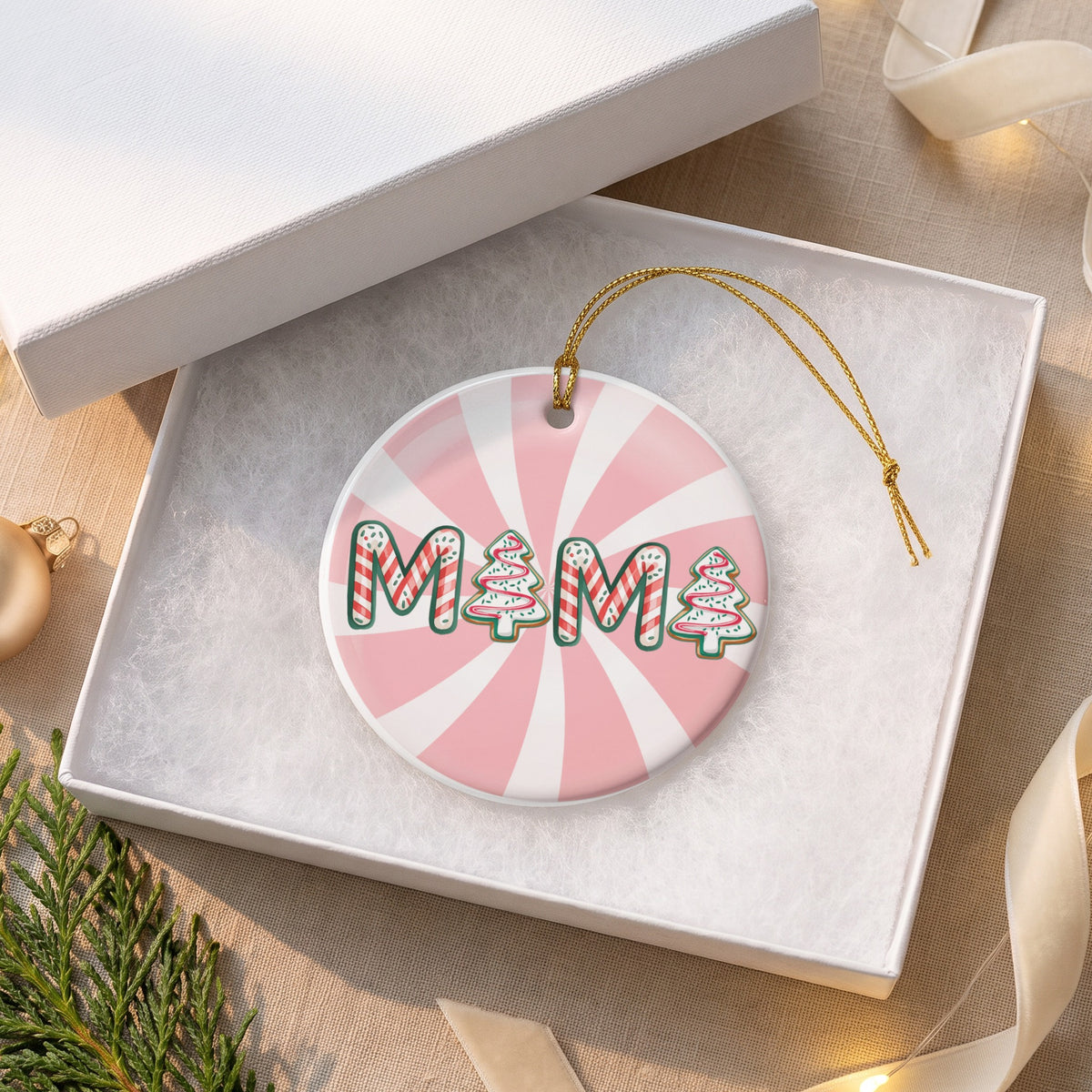 Round ornament with "MAMA" text and Christmas trees on pink and white background.
