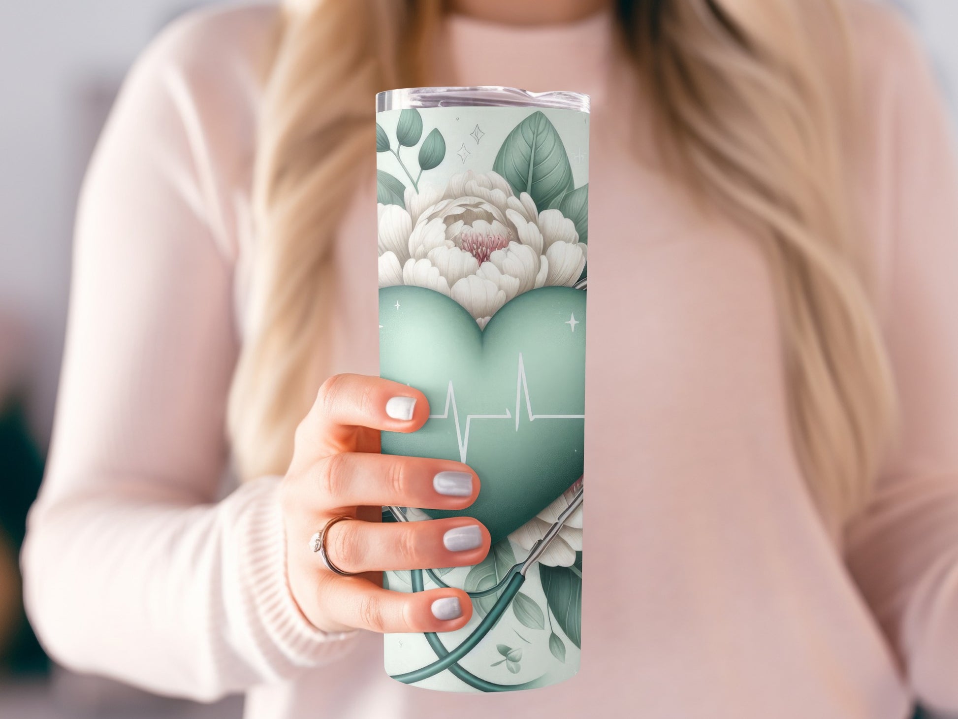 Woman holding a teal tumbler with floral and heart-shaped ECG design.