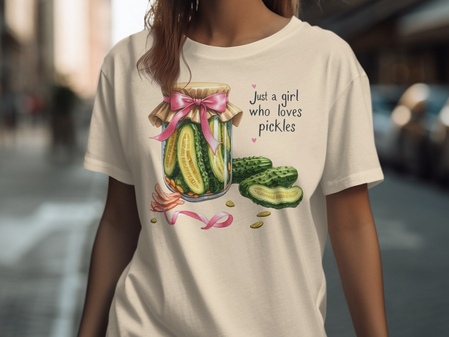Woman wearing a cream t-shirt with a pickle jar graphic and text.