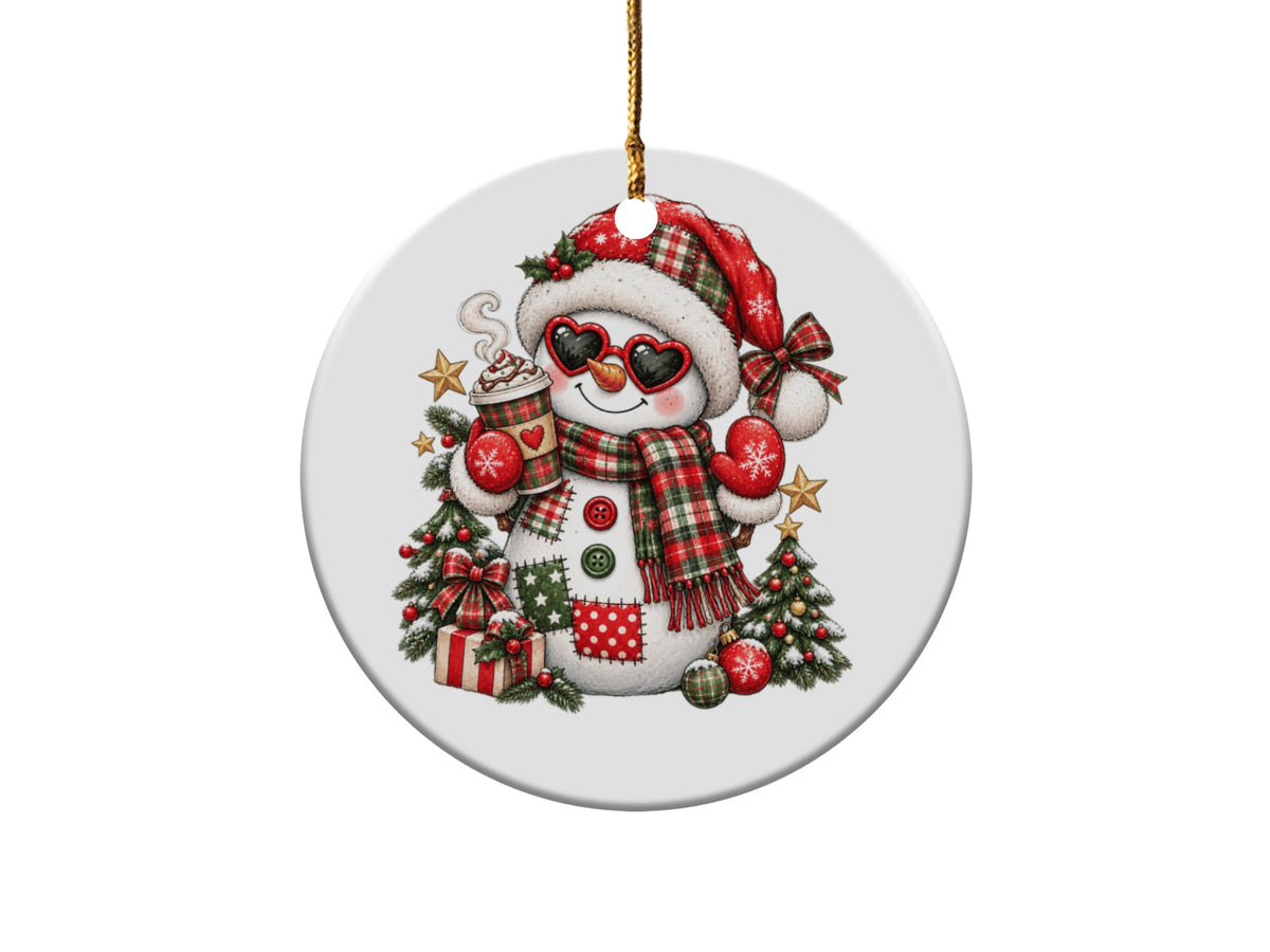 Christmas ornament of a snowman wearing a Santa hat, heart sunglasses, and plaid scarf, holding hot cocoa.