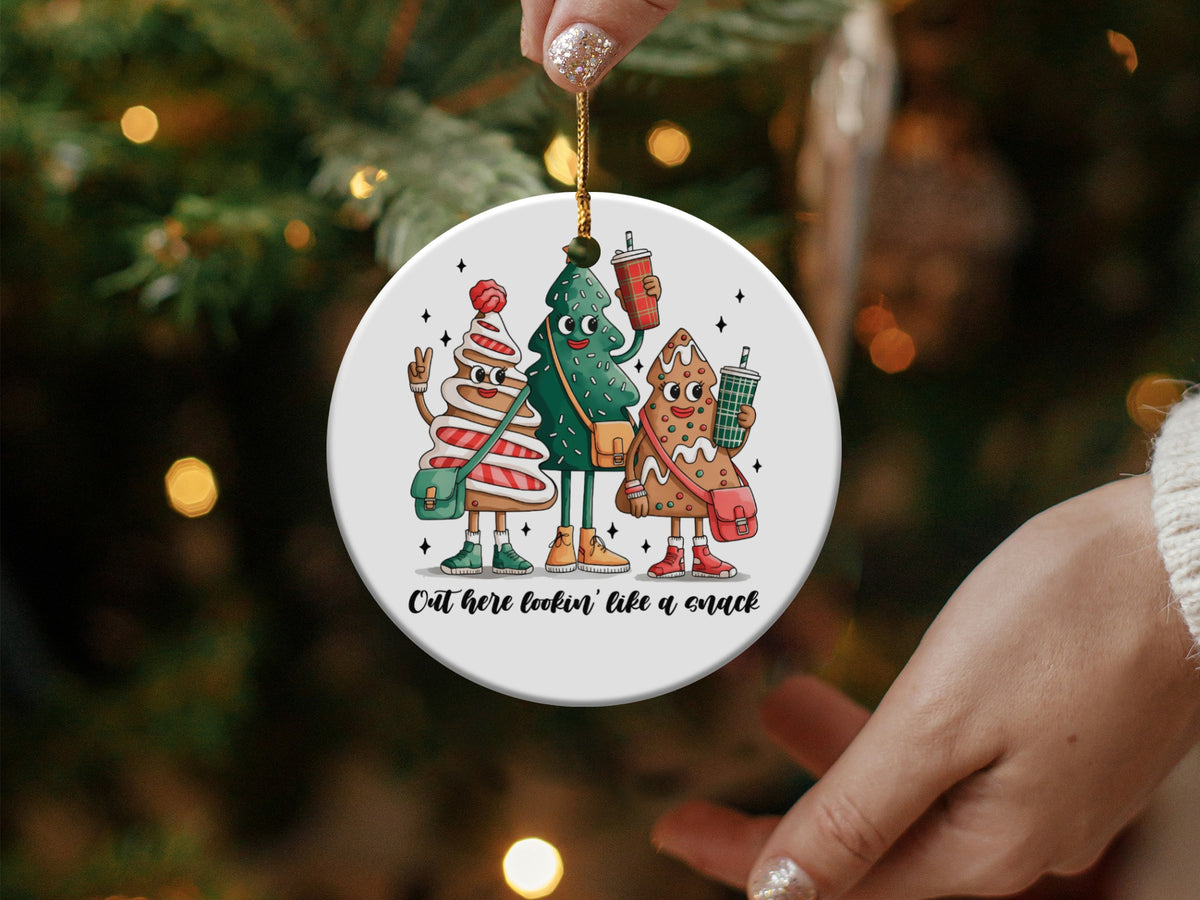 Round ornament with cartoon gingerbread man, Christmas tree, and cookie holding drinks.