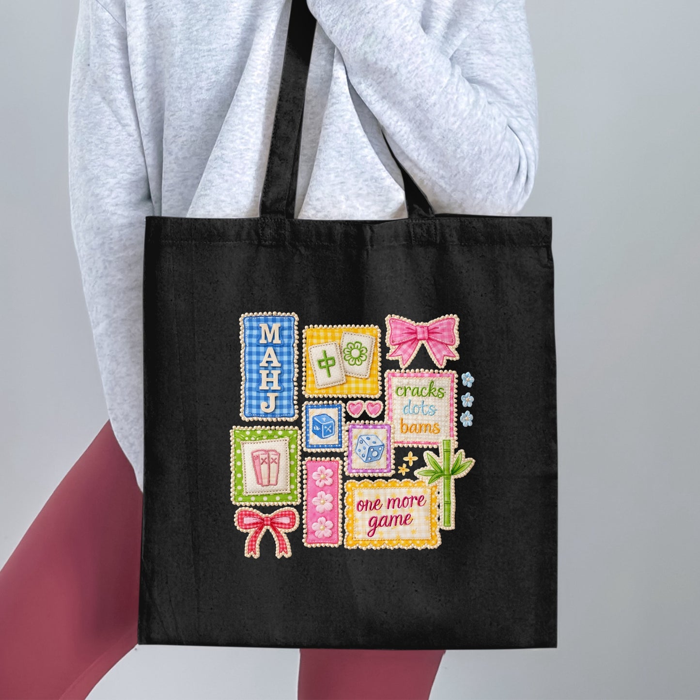 Black tote bag with a colorful embroidered Mahjong design featuring text and game elements.
