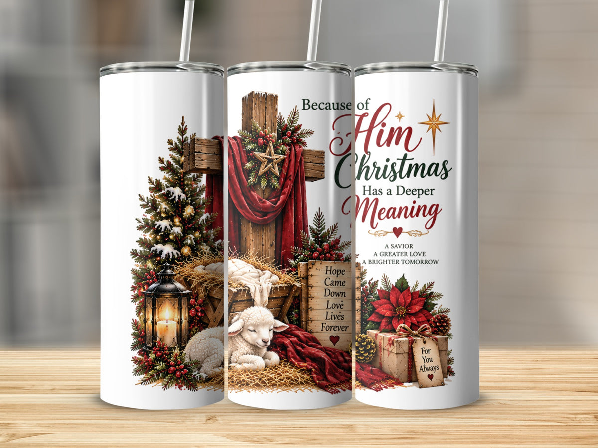 Three tall, white tumblers with straws display a Christian Christmas nativity design featuring a cross, a manger, and text reading Because of Him Christmas has a Deeper Meaning.