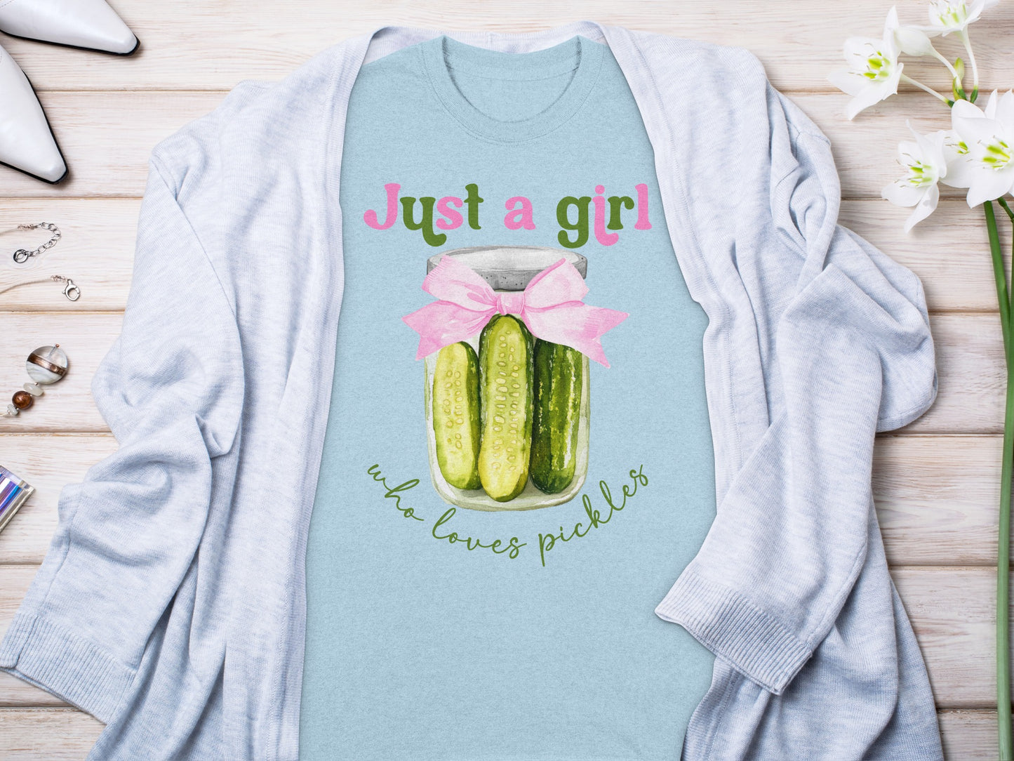 Light blue t-shirt with "Just a girl who loves pickles" text and bow.