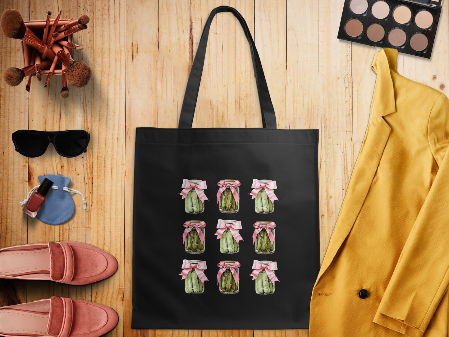 Black tote bag featuring a grid of nine jars of pickles tied with pink bows.
