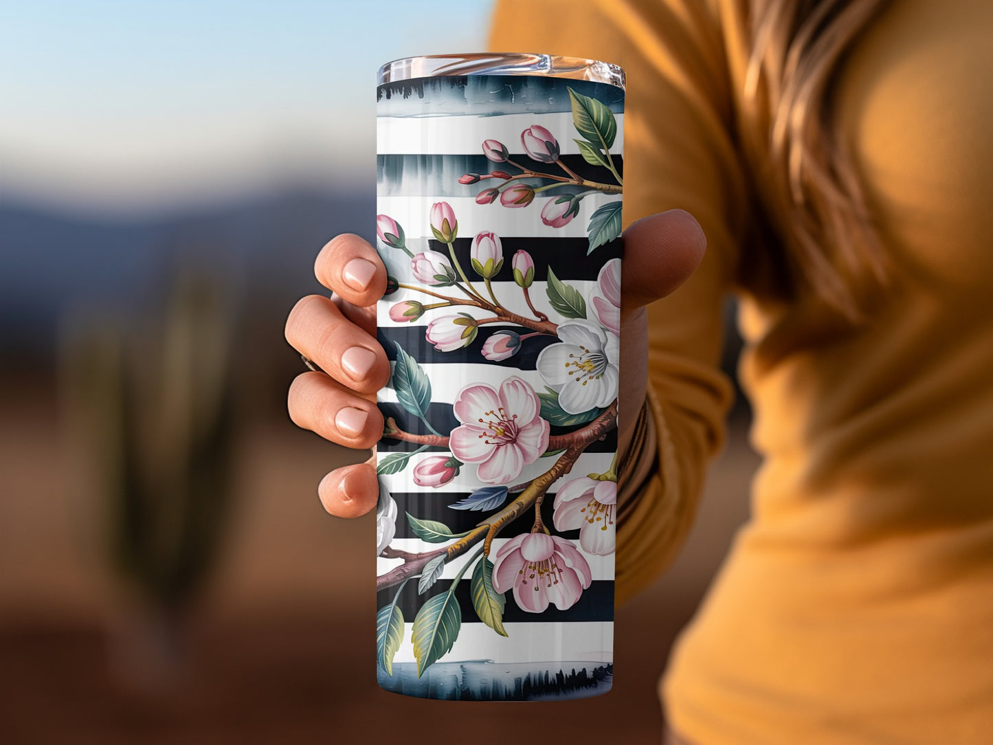 Tumbler with white cherry blossoms and black and white stripes.