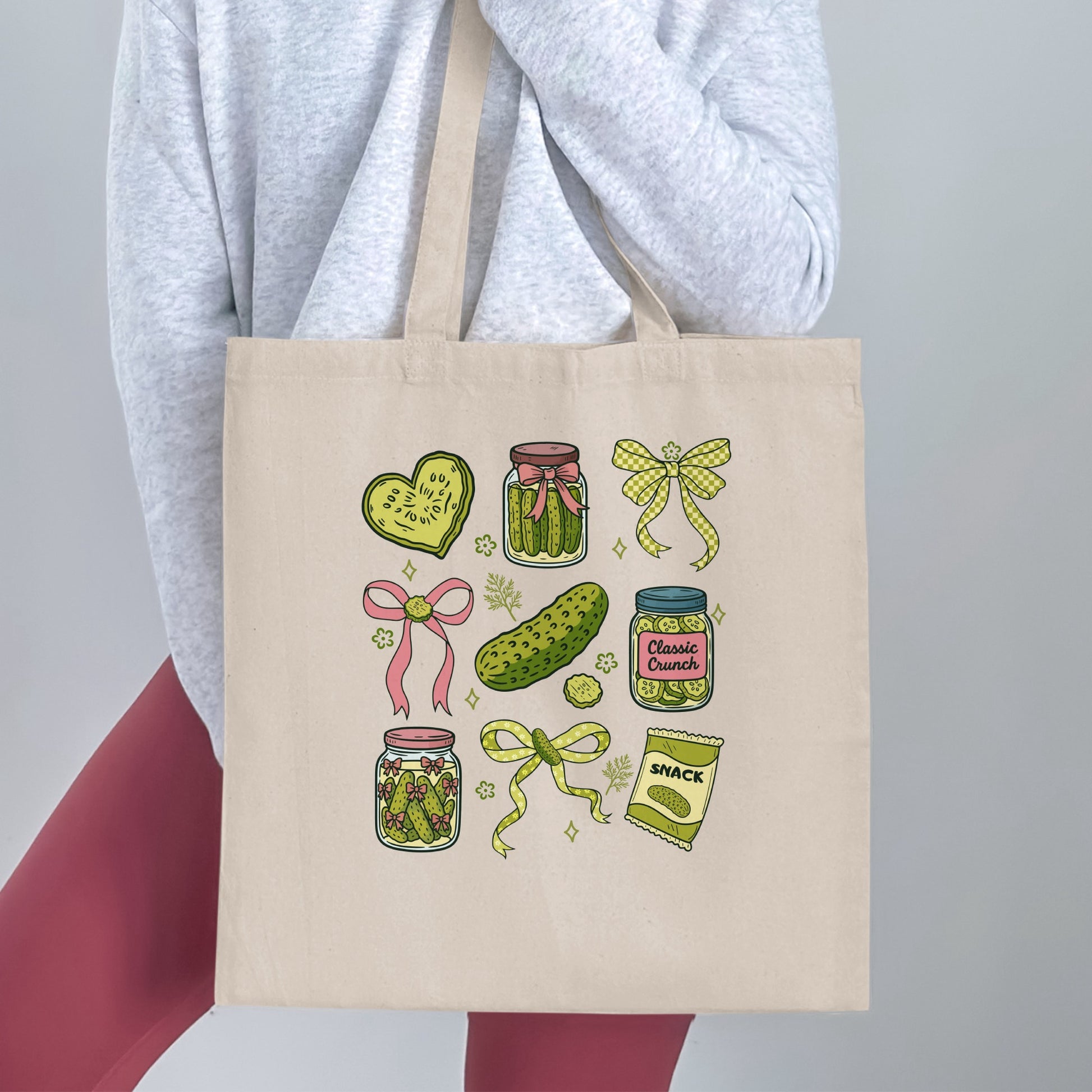 Tote bag with jars of pickles, a pickle heart, and a snack bag.