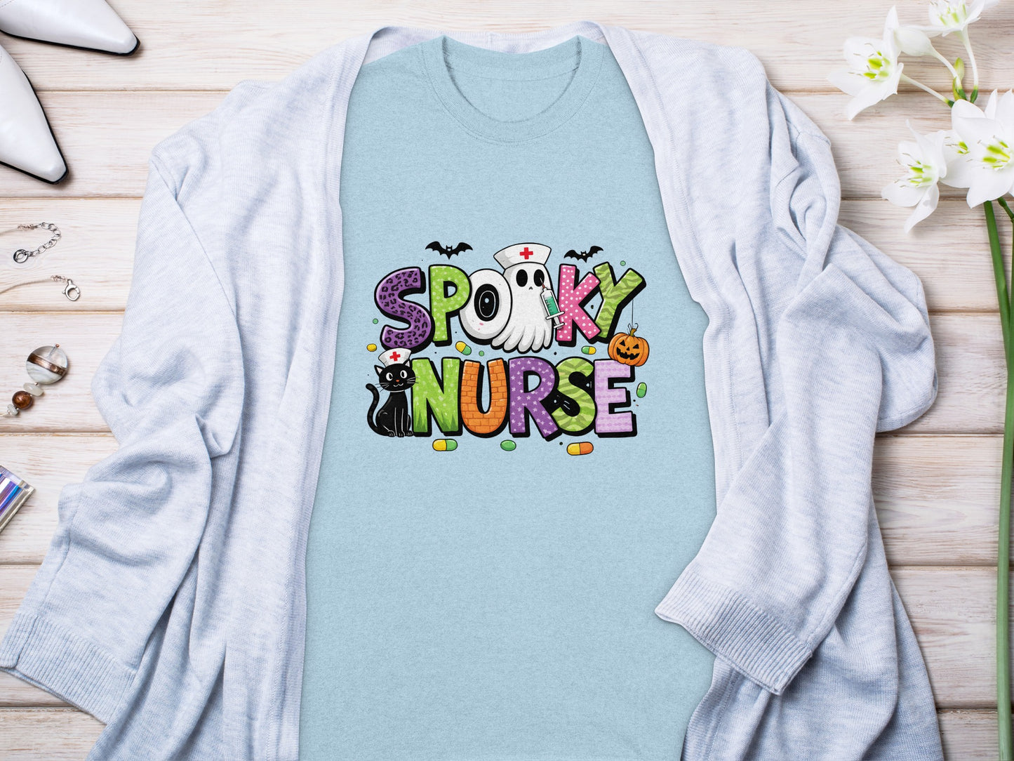 "Spooky Nurse" text with Halloween graphics on a light blue t-shirt.