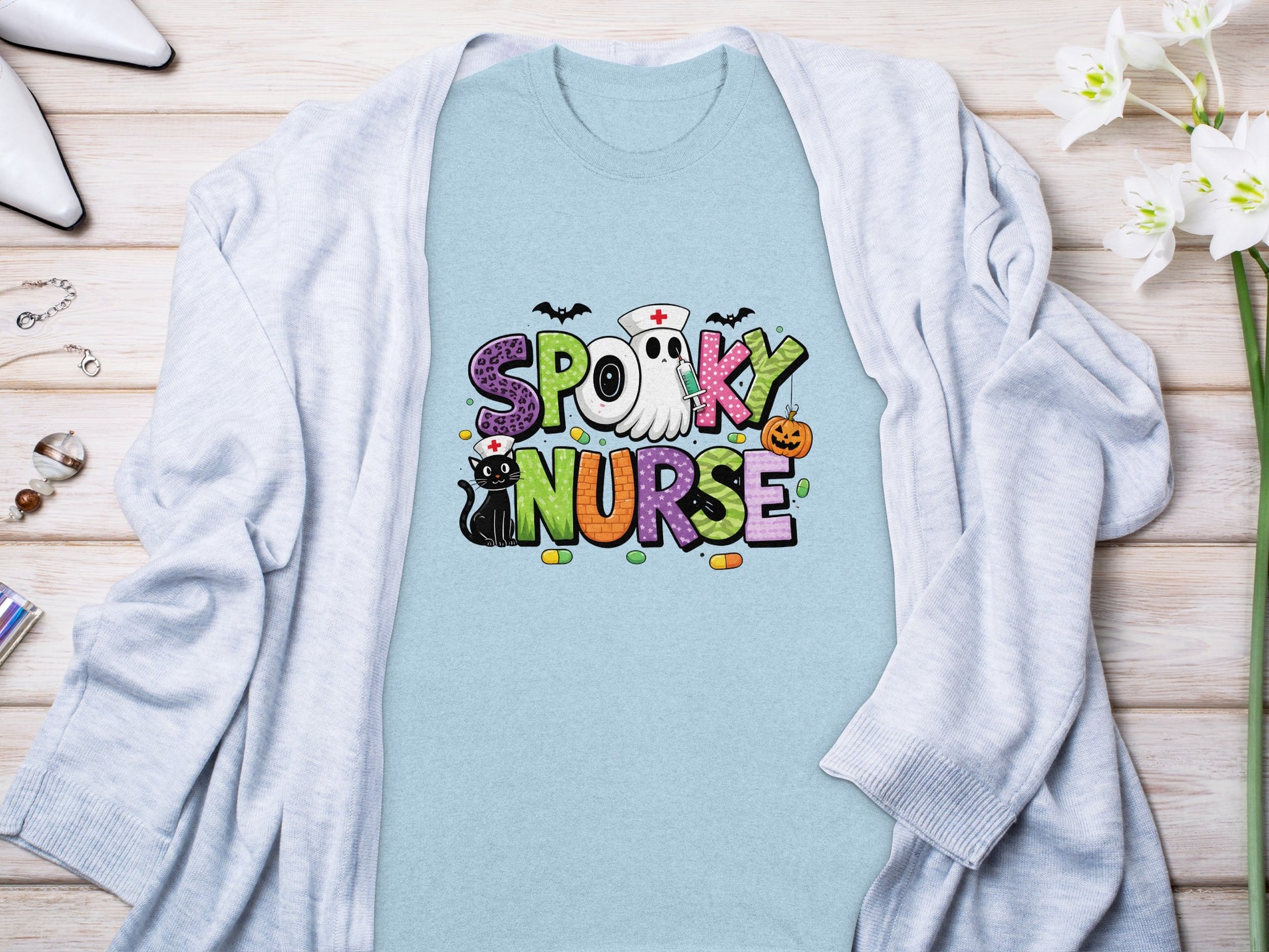 "Spooky Nurse" text with Halloween graphics on a light blue t-shirt.