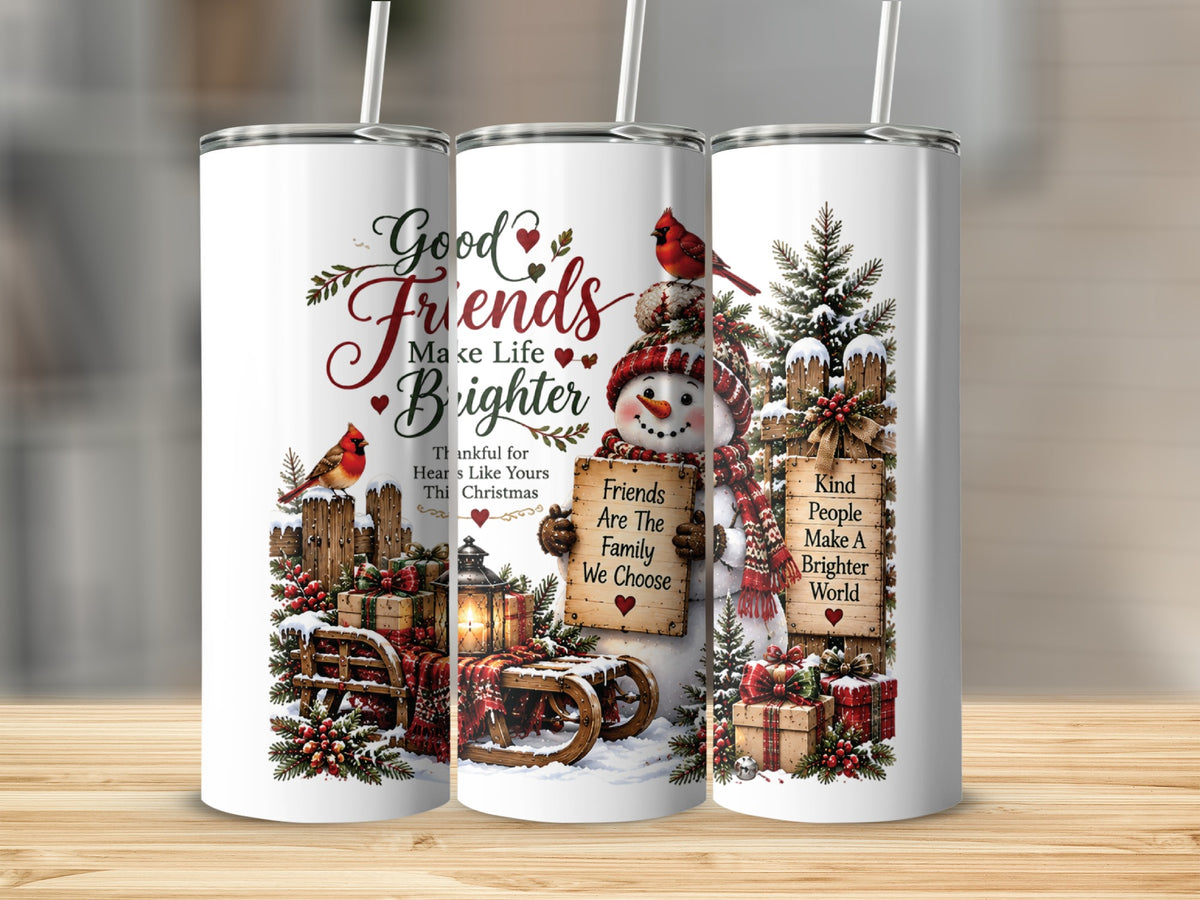 Three white travel tumblers featuring a snowman, cardinals, festive text, and winter scenes standing on wooden surface.