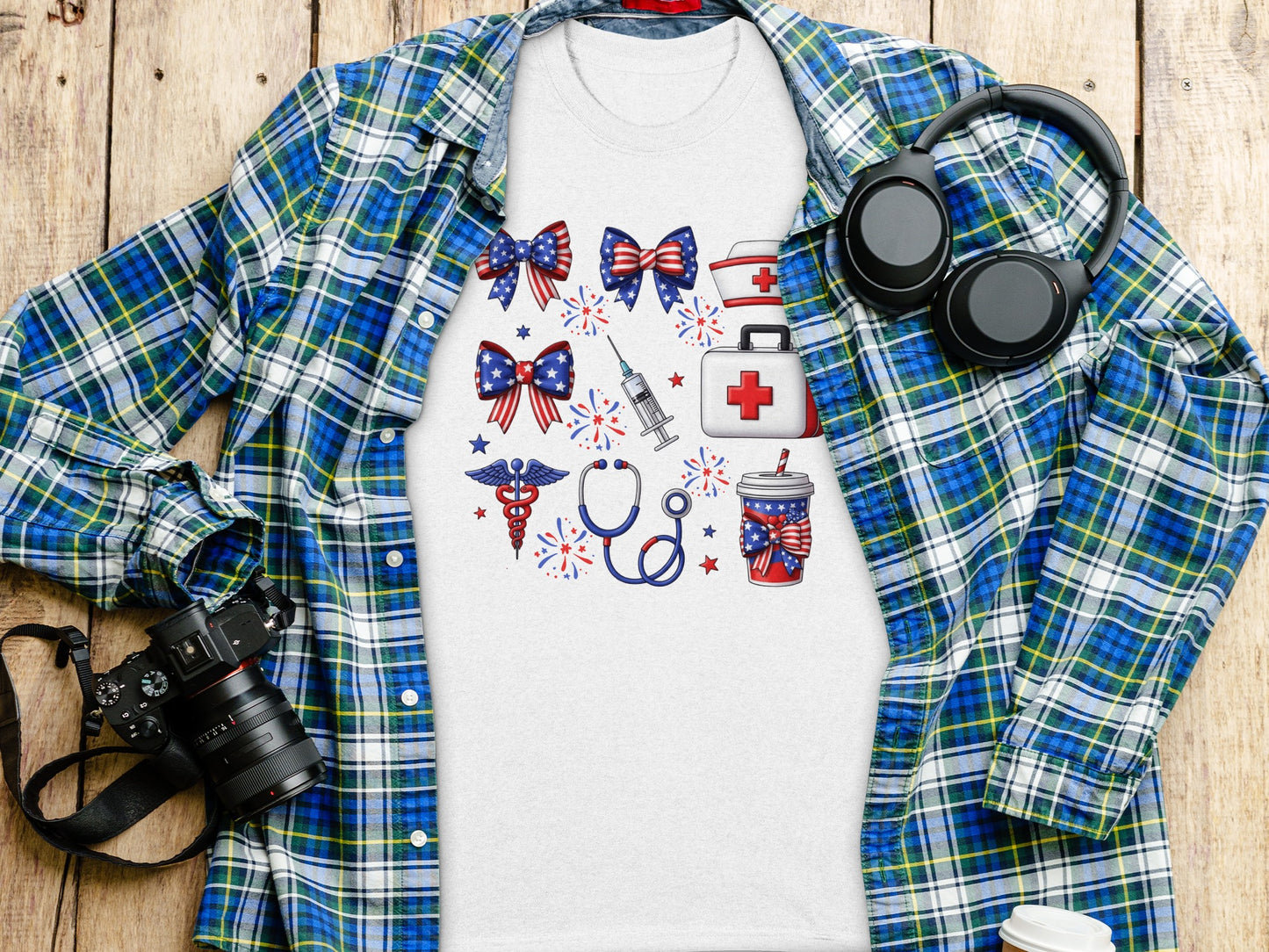 White t-shirt with patriotic medical symbols and headphones on a wooden background.