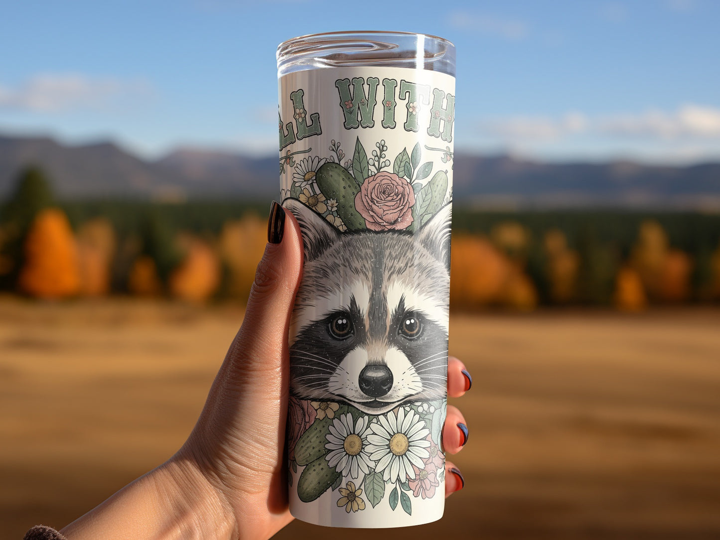 Tumbler with raccoon, flowers, and text "ALL WITH".