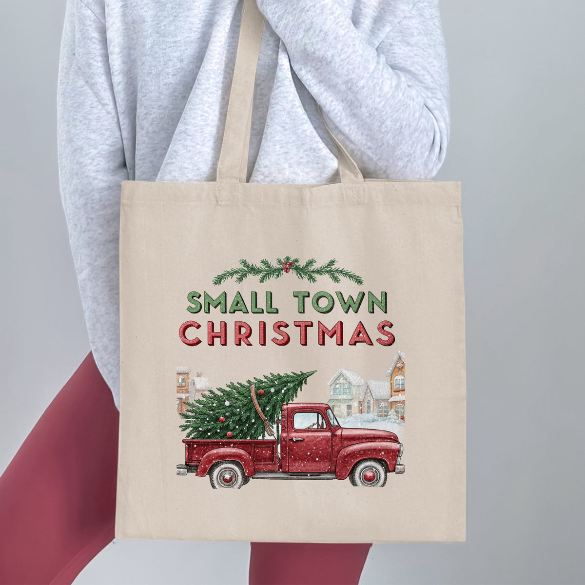 Tote bag with a red truck hauling a Christmas tree and text "Small Town Christmas".