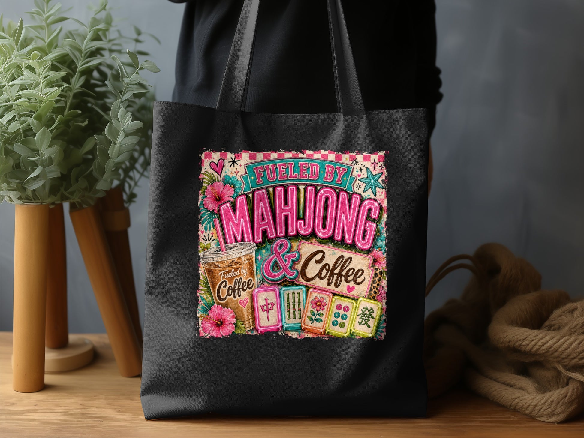 Black tote bag with "Fueled by Mahjong & Coffee" graphic and mahjong tiles.