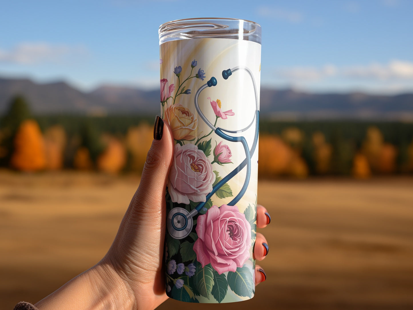 Tall tumbler with stethoscope and roses design held by a hand.