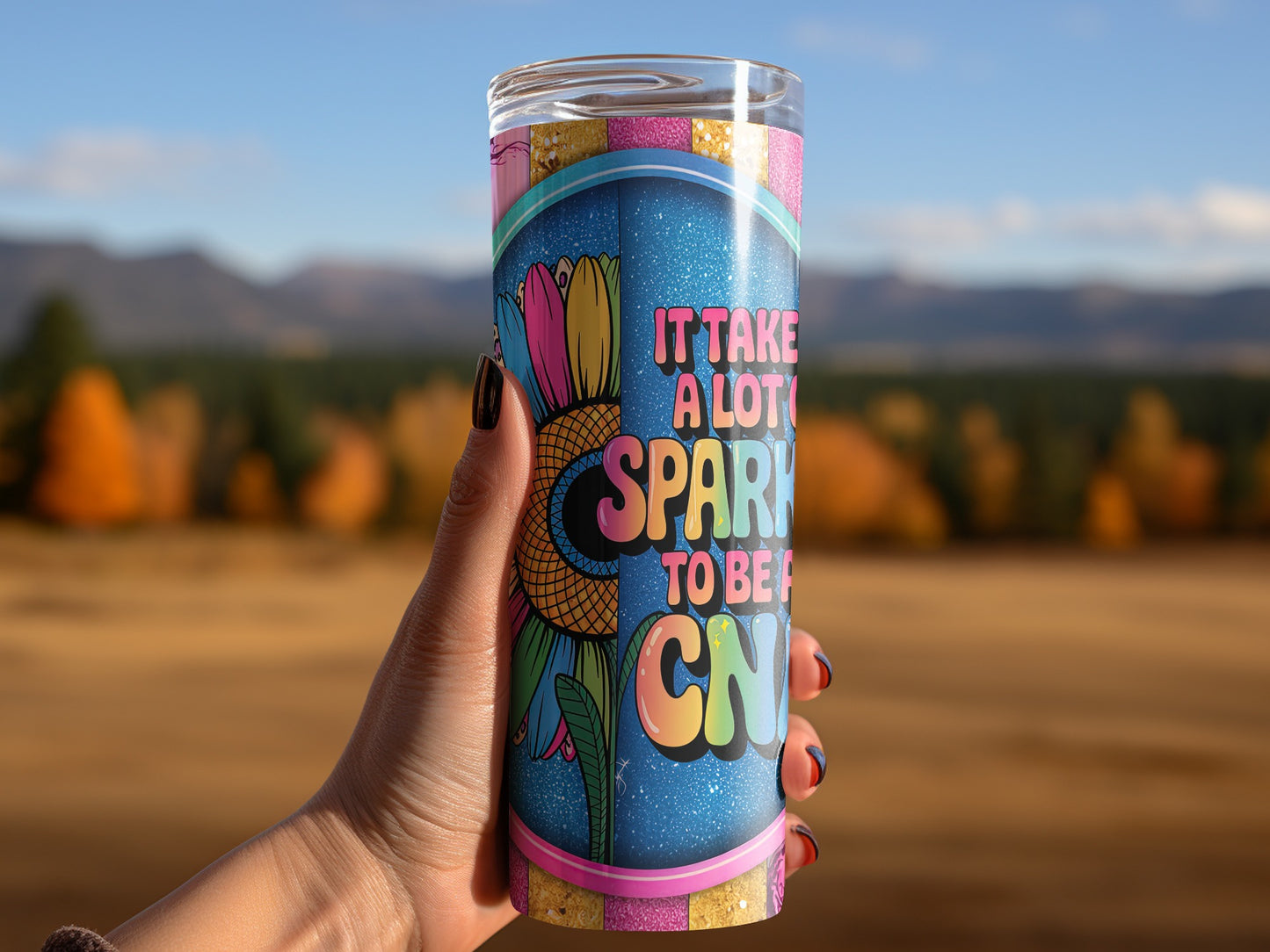 Tumbler with colorful sunflower design and "It takes a lot of sparkle to be one" text.
