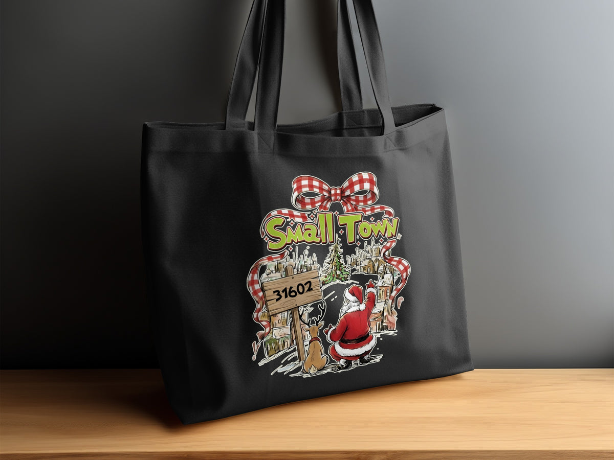 Black tote bag with "Small Town" graphic, Santa, reindeer, and zip code 31602.