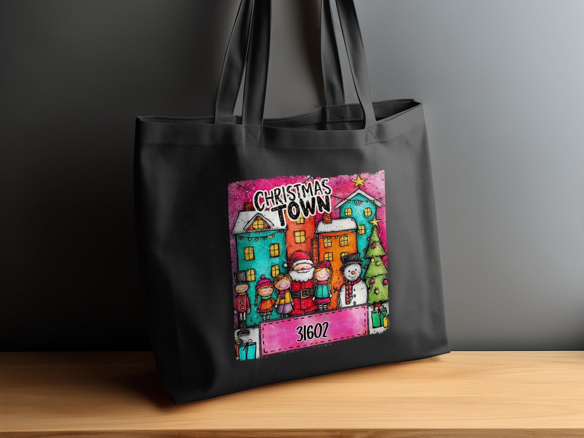 Black tote bag with a Christmas Town design featuring Santa, children, snowman, and buildings.