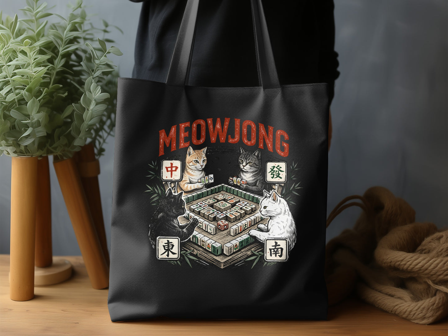 Black tote bag featuring four cats playing mahjong, with text "MEOWJONG".