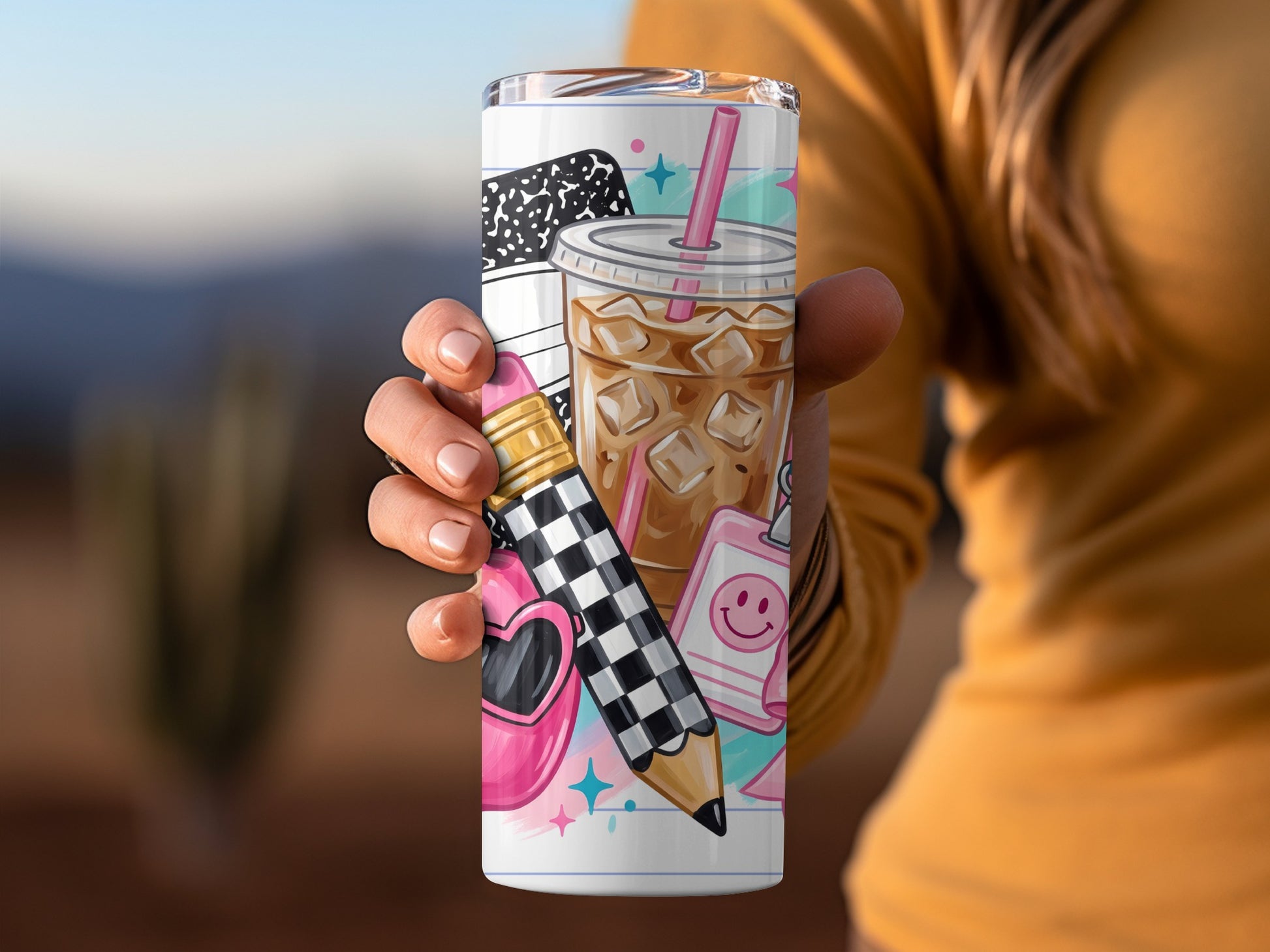 Tumbler with coffee, notebook, pencil, heart sunglasses, and smiley face designs.