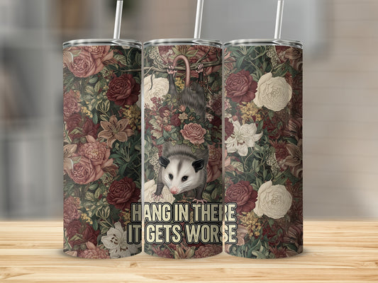Opossum hanging from floral branch with text "Hang in there it gets worse."