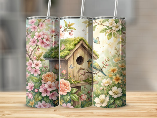 Three tumblers featuring a birdhouse, flowers, and butterflies on a wooden surface.