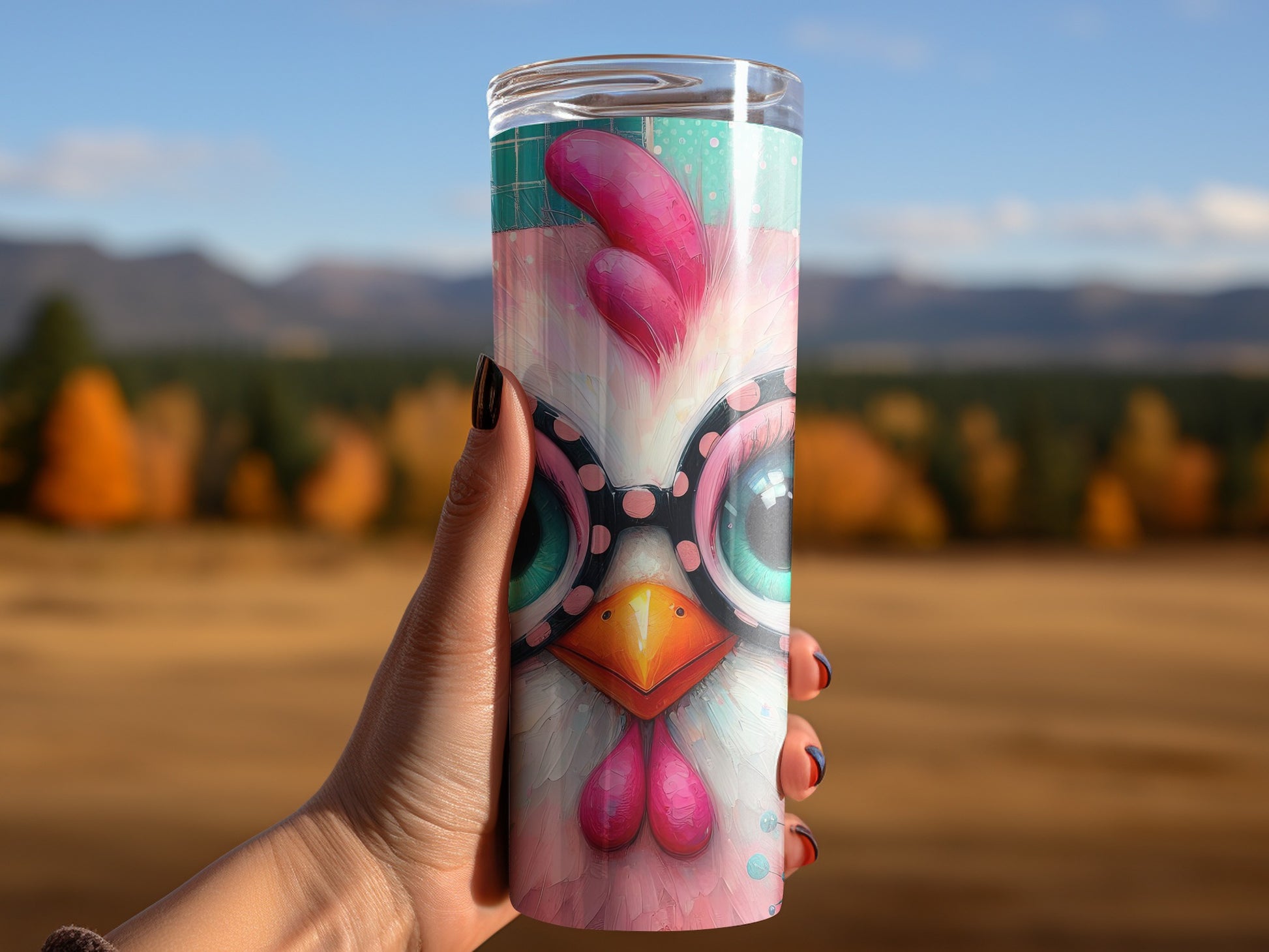 Hand holding a tumbler with a cartoon chicken face and pink polka dots.