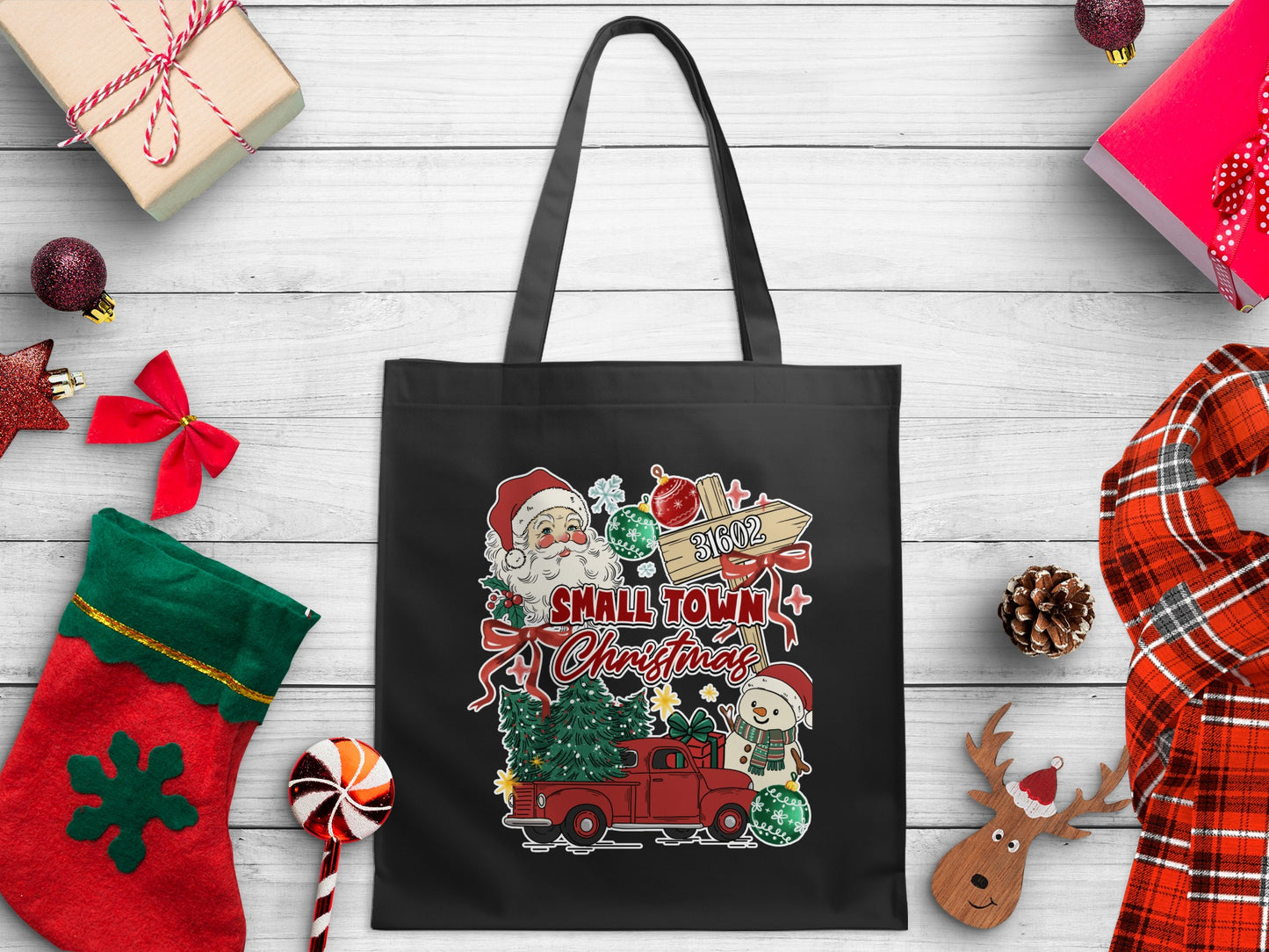Black tote bag with a festive Christmas graphic featuring Santa, snowman, truck, and trees.