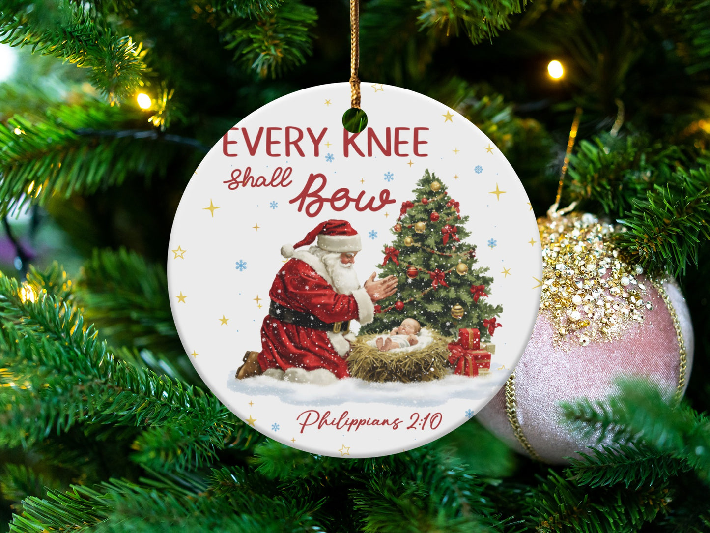Ornament with Santa kneeling before baby Jesus, Christmas tree, and text.