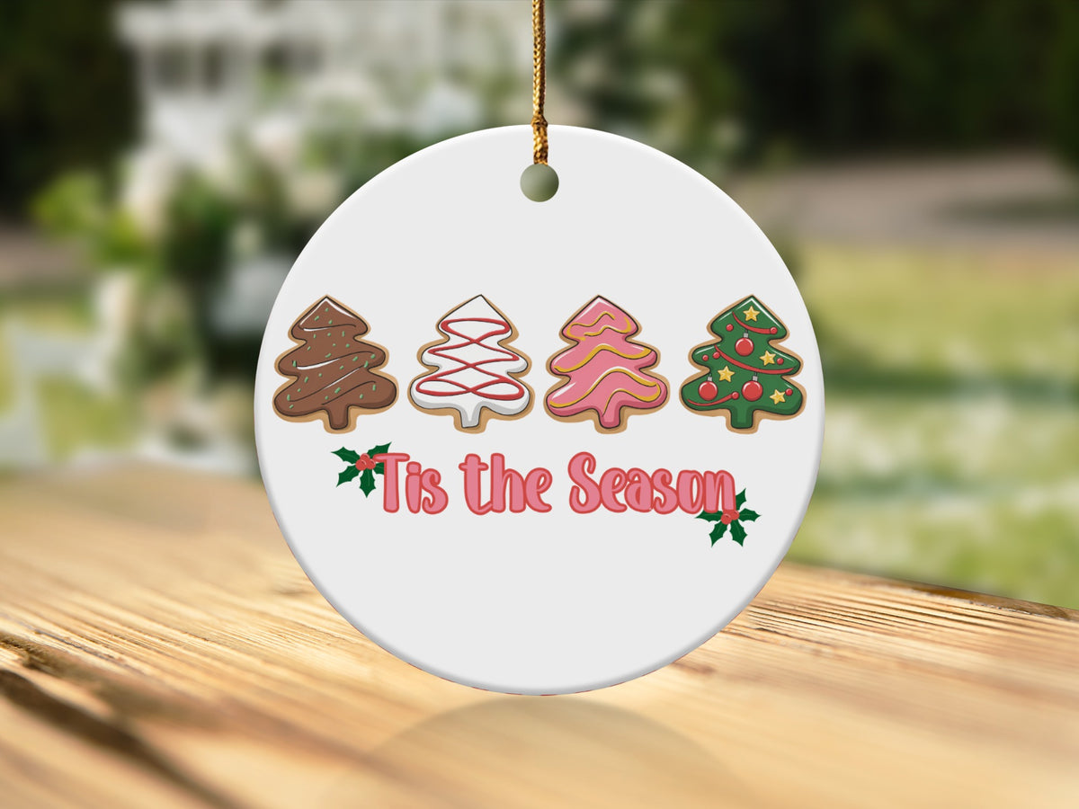 Round Christmas ornament with four frosted tree cookies and "Tis the Season" text.