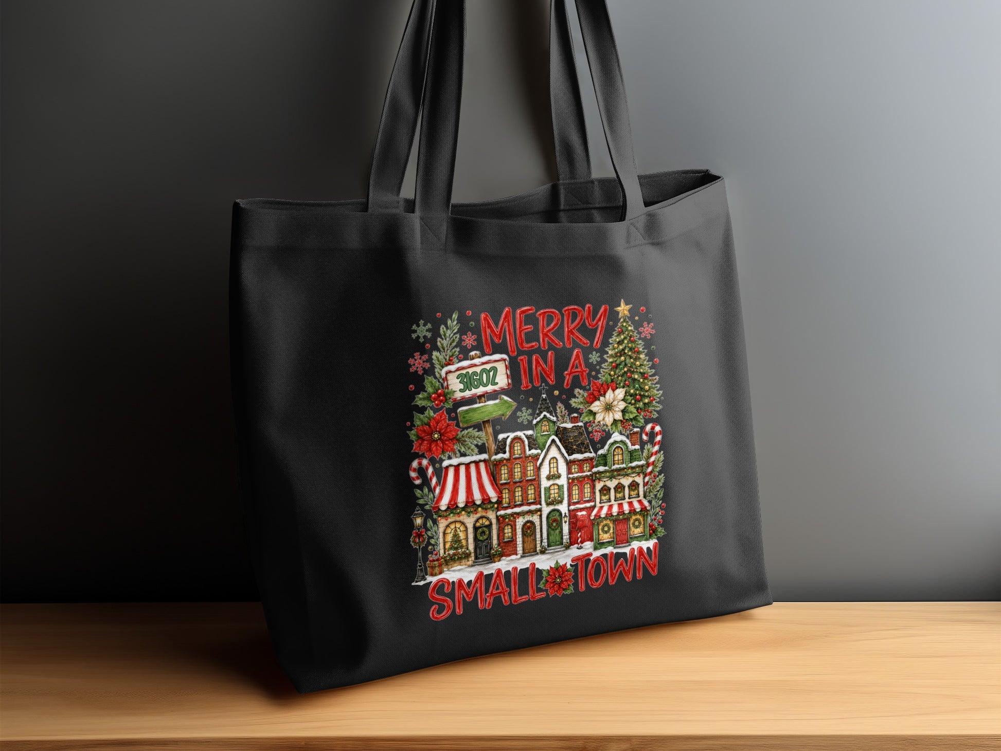 Black tote bag with "Merry In A Small Town" Christmas village graphic.