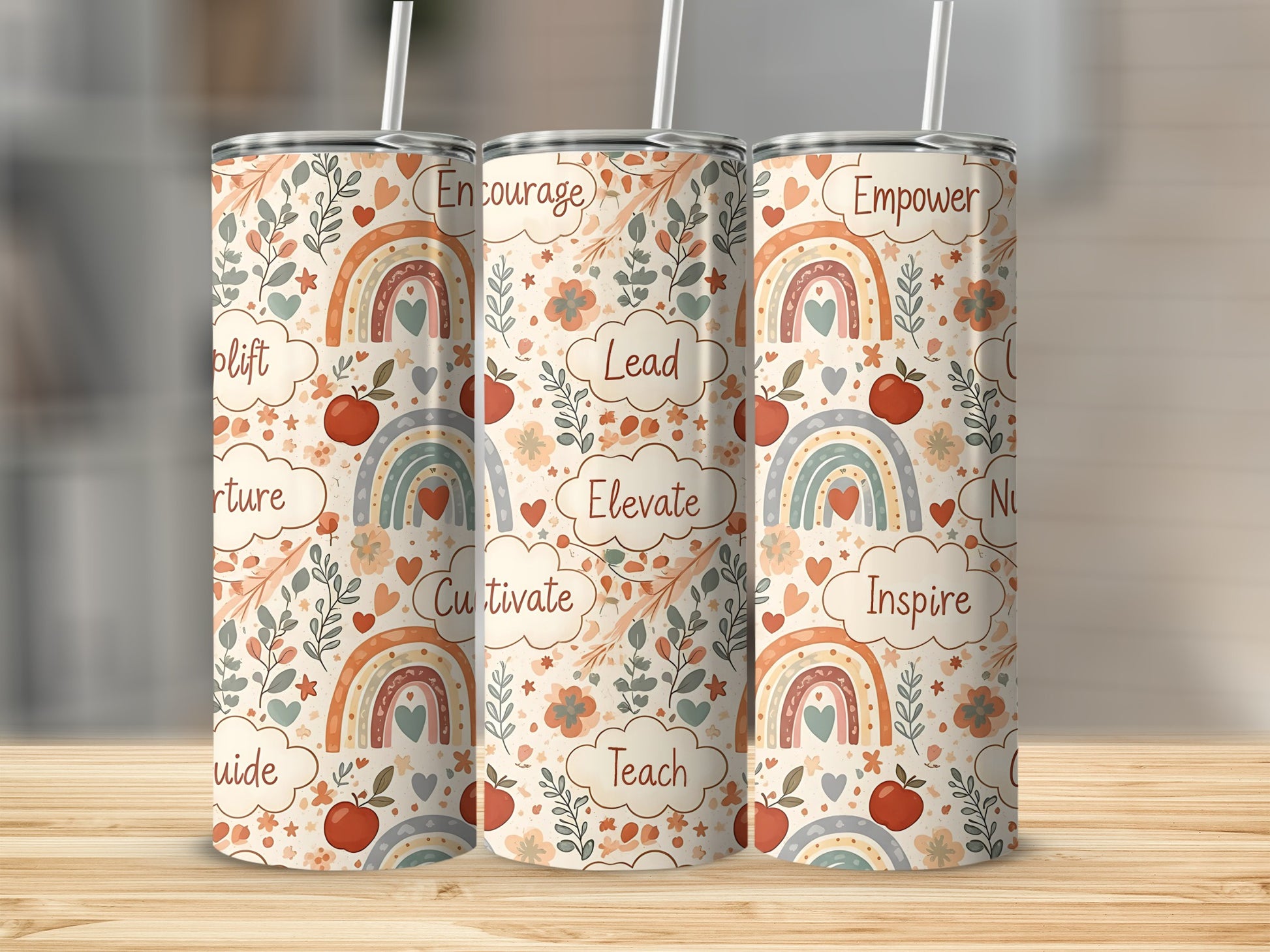 Three tumblers with rainbow and floral pattern, featuring words like Encourage, Lead, and Empower.