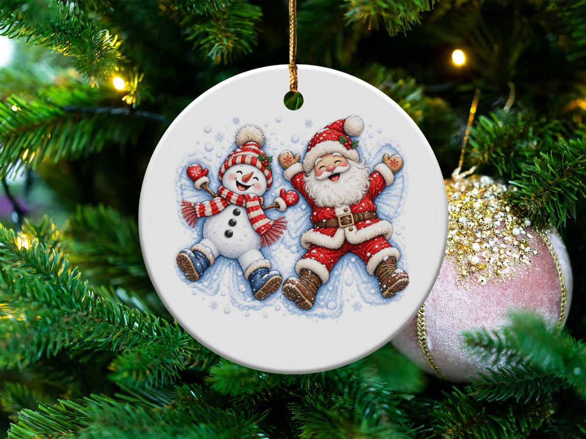 Round ceramic ornament with Santa and snowman making snow angels.