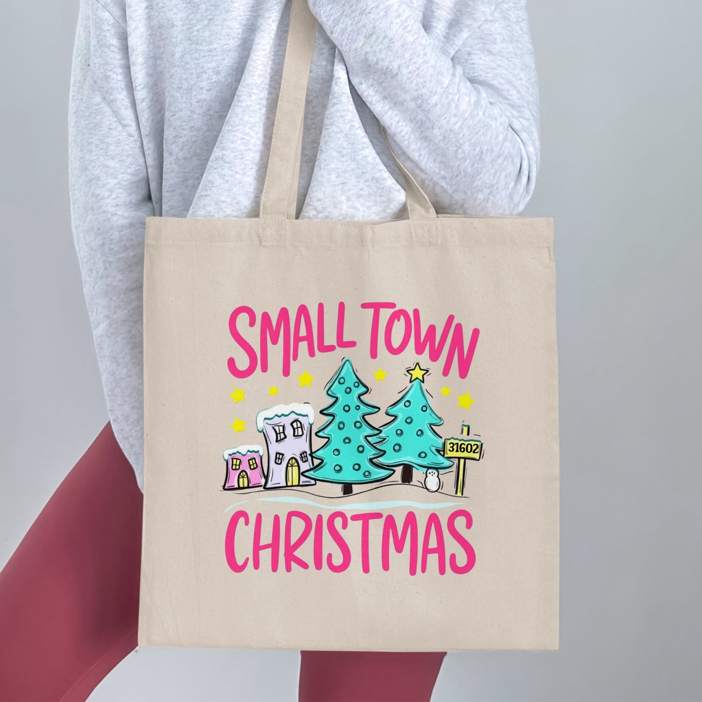 Tote bag with "SMALL TOWN CHRISTMAS" text and cartoon holiday scene.