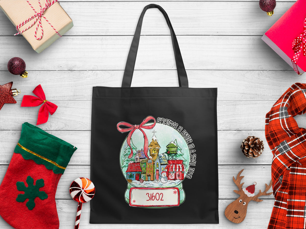 Black tote bag with Christmas snow globe design and zip code 31602.