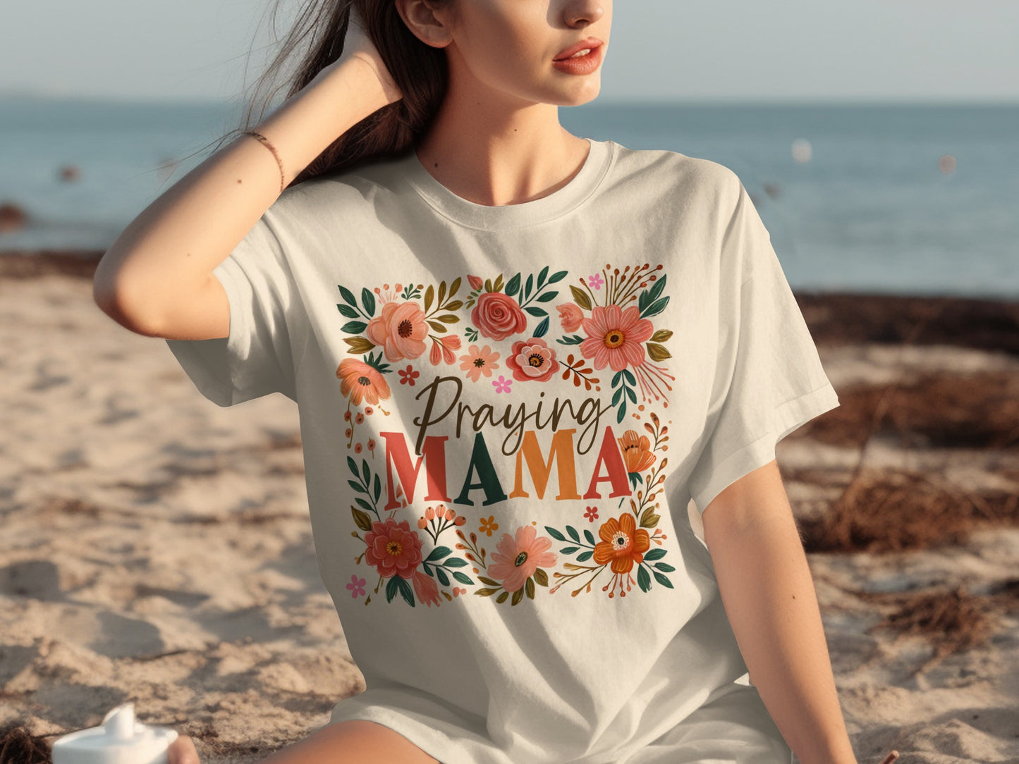 White t-shirt with "Praying Mama" text surrounded by floral illustrations.