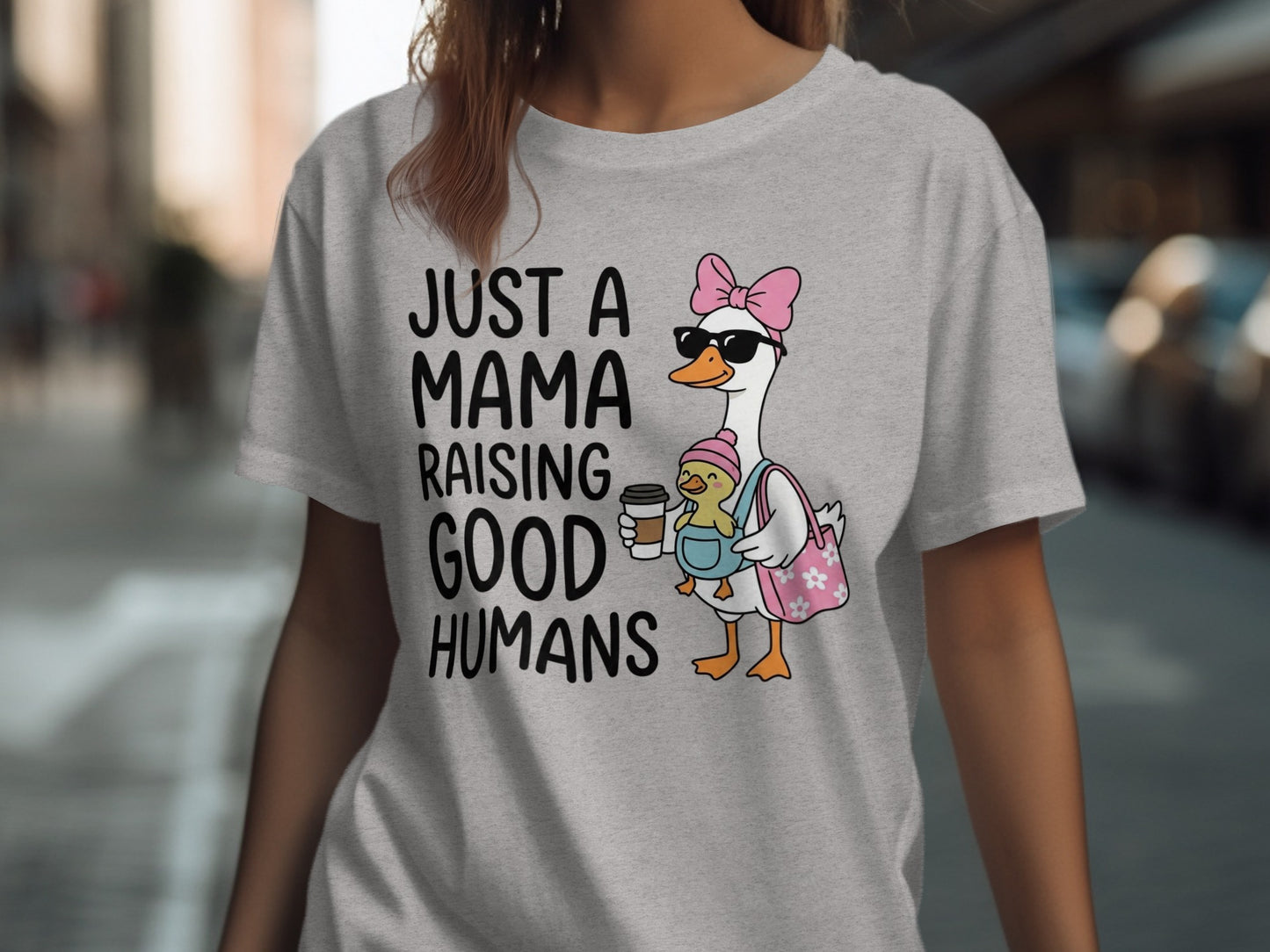 Mama goose wearing pink bow, holding baby, "JUST A MAMA RAISING GOOD HUMANS".