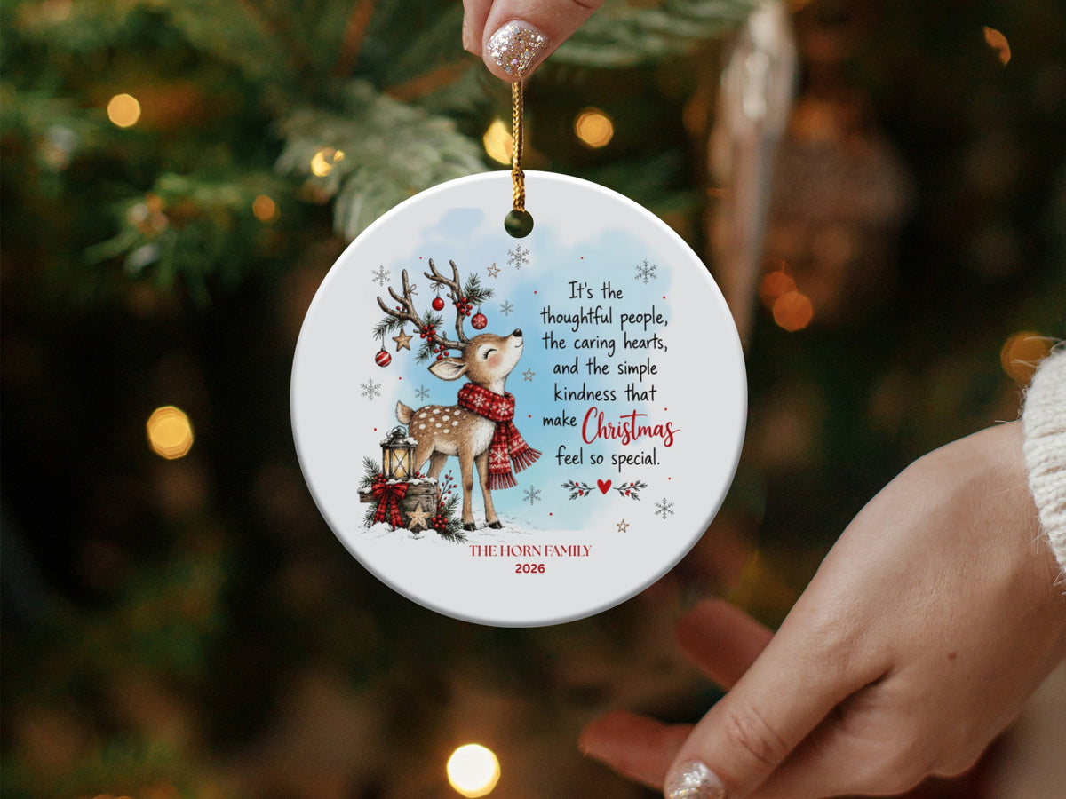 A round white Christmas ornament features a reindeer graphic, holiday text, and family name.