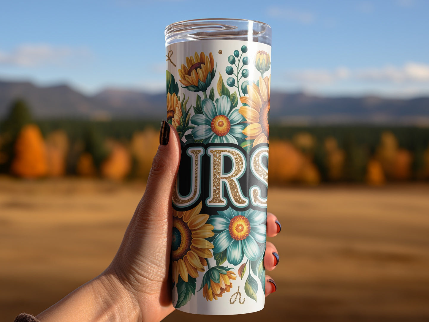 Tumbler with sunflowers and floral design, held in hand.