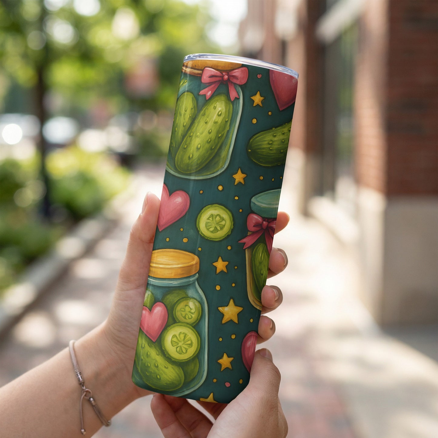 Jar of pickles and hearts pattern on a stainless steel tumbler.