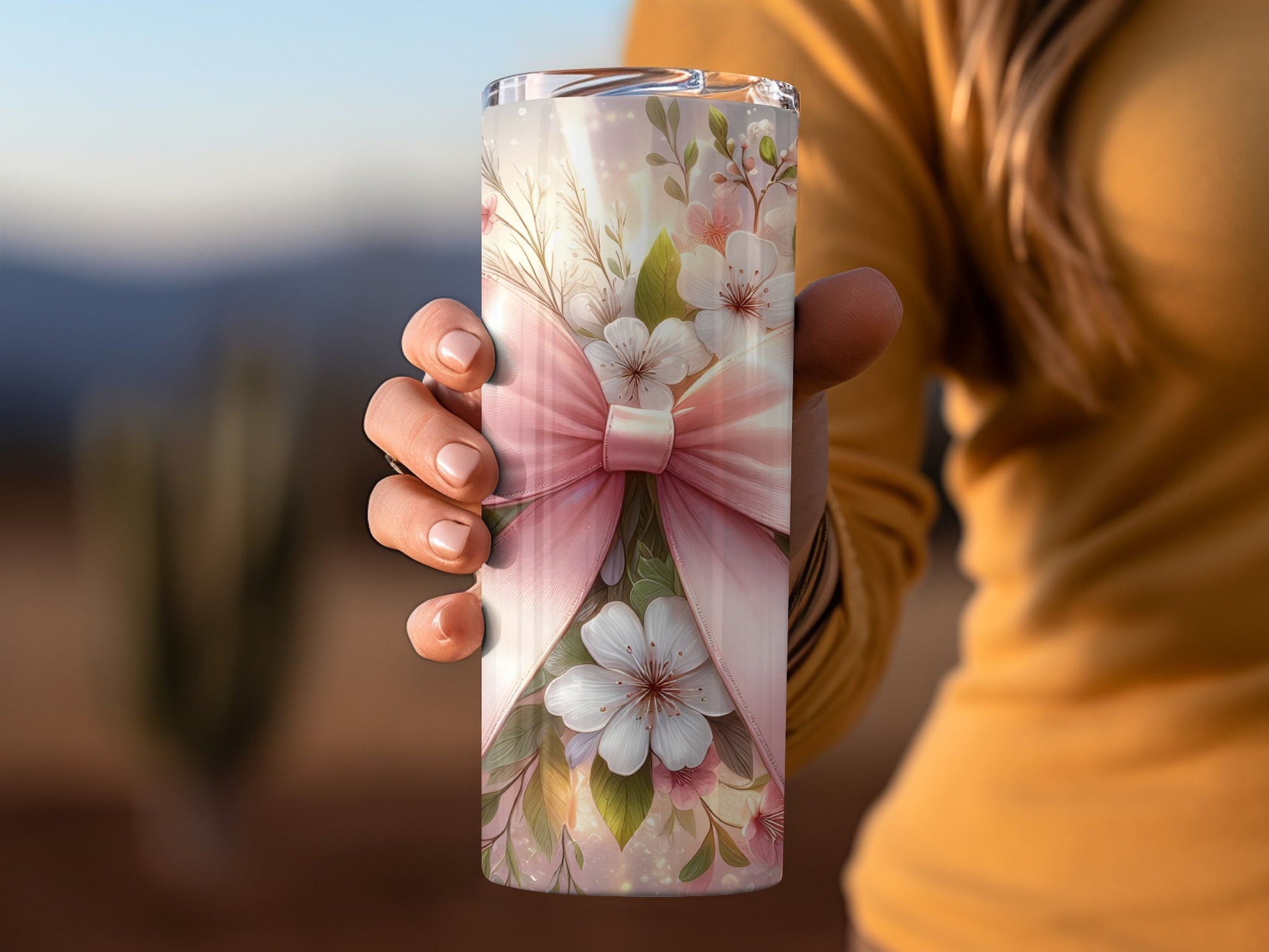 Pink floral pattern tumbler with a bow, held by a hand.