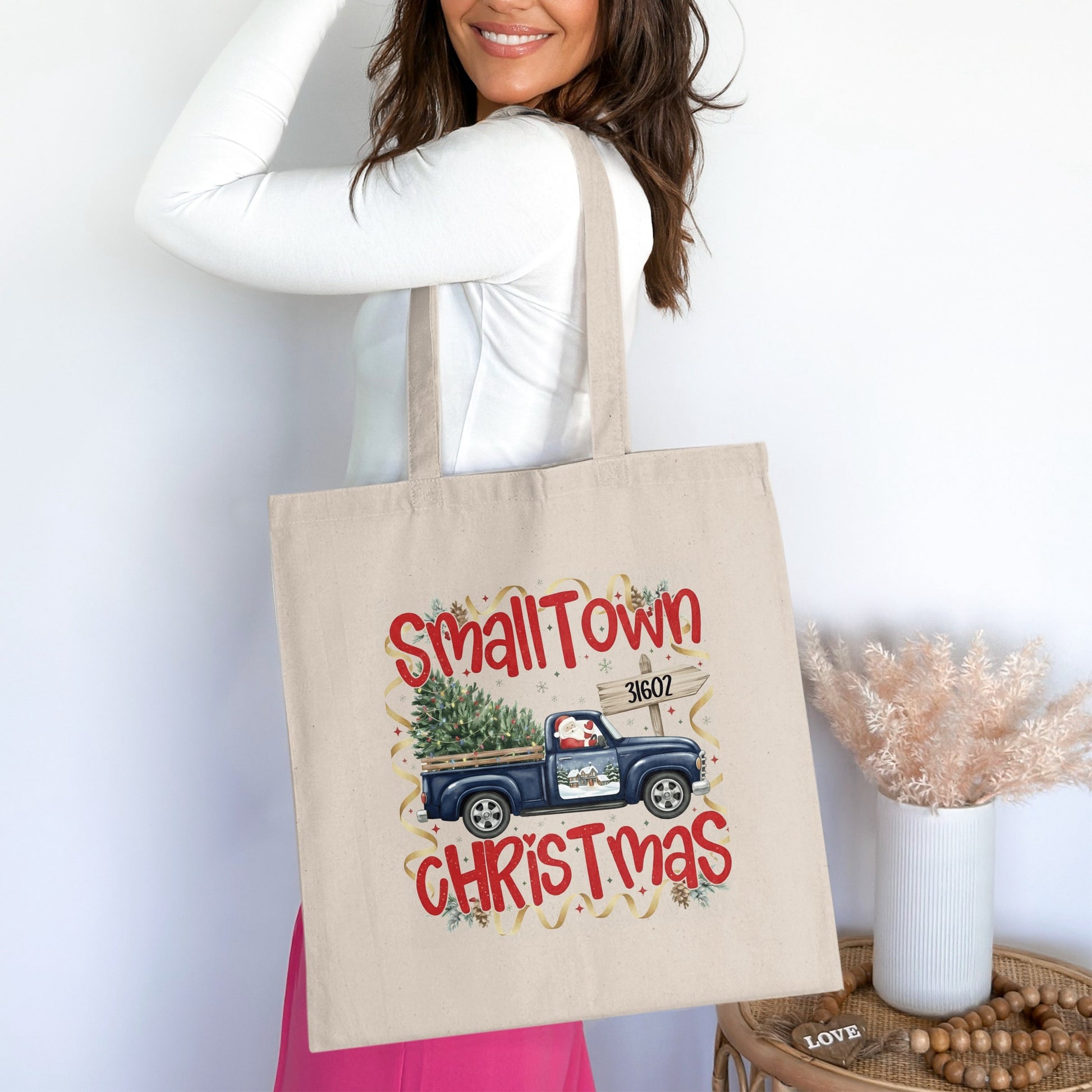 Canvas tote bag with "SmallTown Christmas" and a blue truck carrying a tree.
