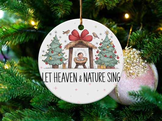 Nativity scene with baby Jesus, Christmas trees, and text "LET HEAVEN & NATURE SING".