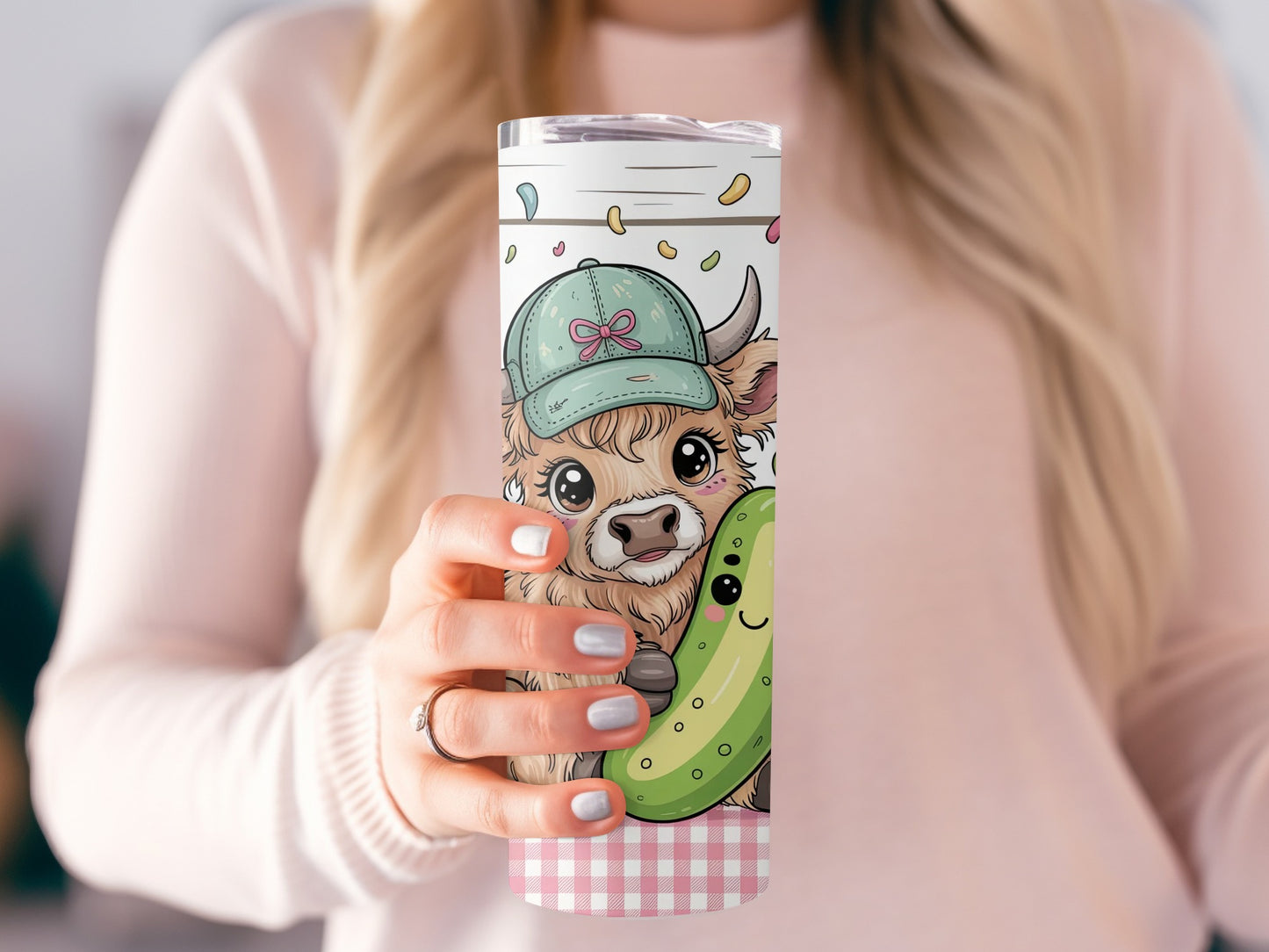 Cow and pickle illustration on a tumbler held by a woman.