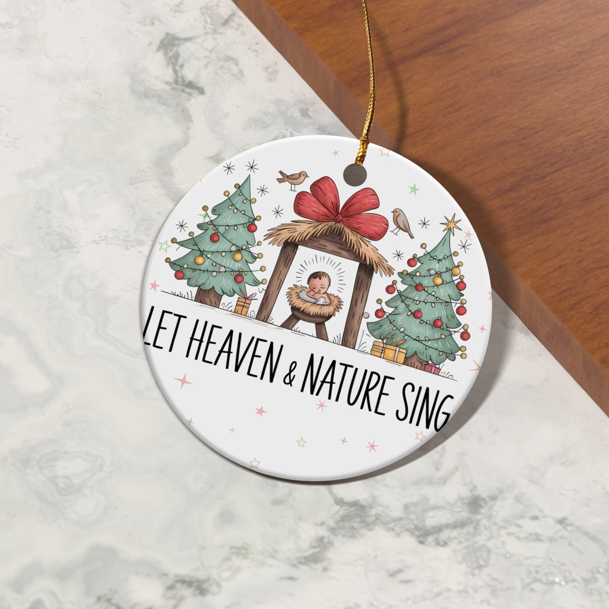 Christmas ornament with nativity scene and "LET HEAVEN & NATURE SING" text.