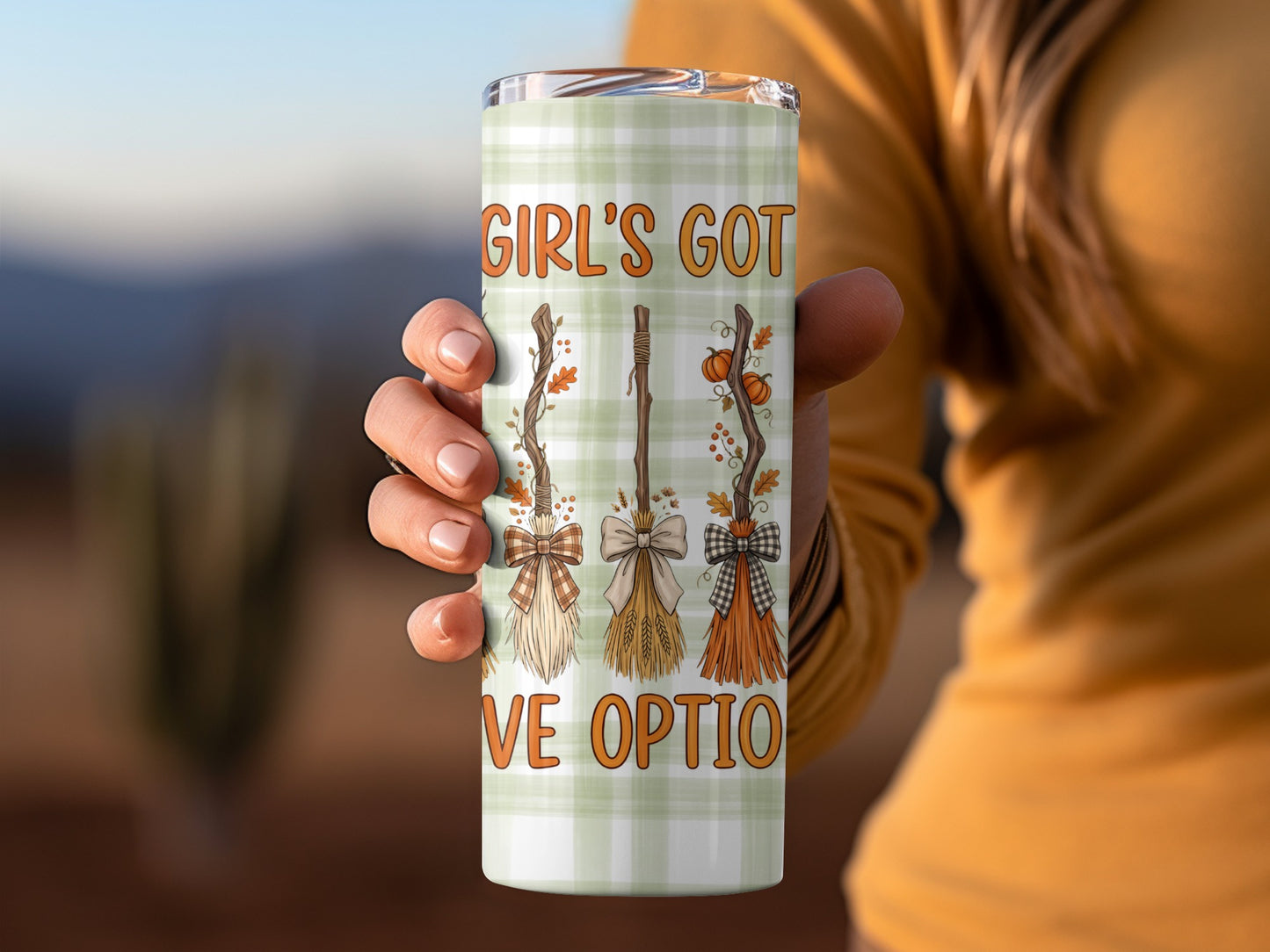Tumbler with plaid pattern, witch brooms, and text "GIRL'S GOT LOVE OPTIO".