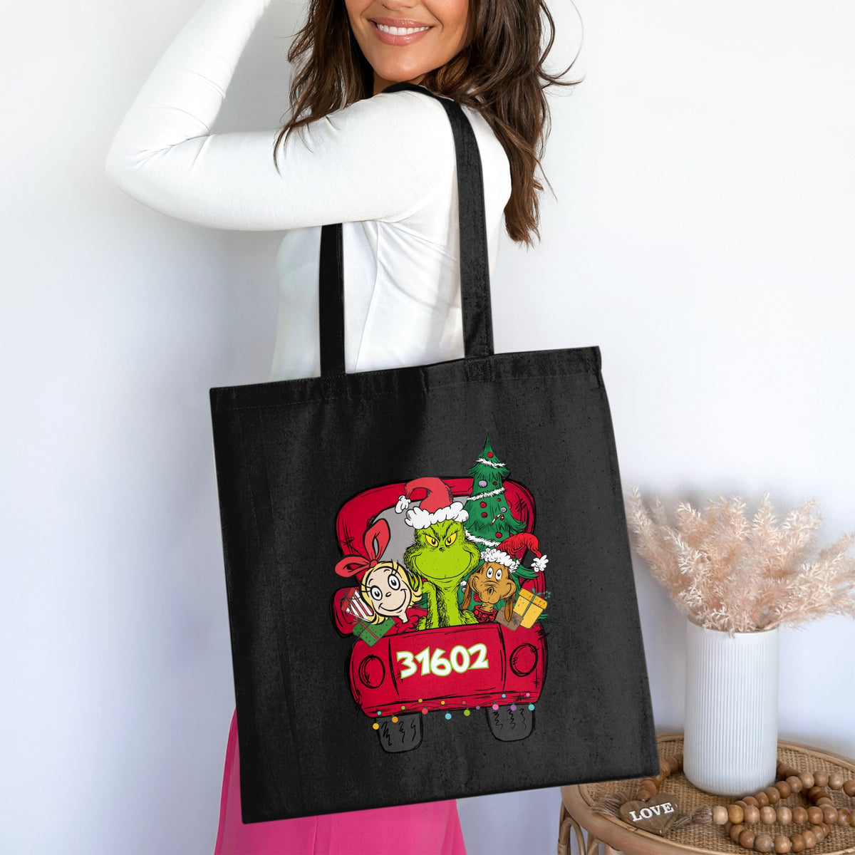 Black tote bag with Grinch characters and Christmas tree in a red truck, featuring "31602".