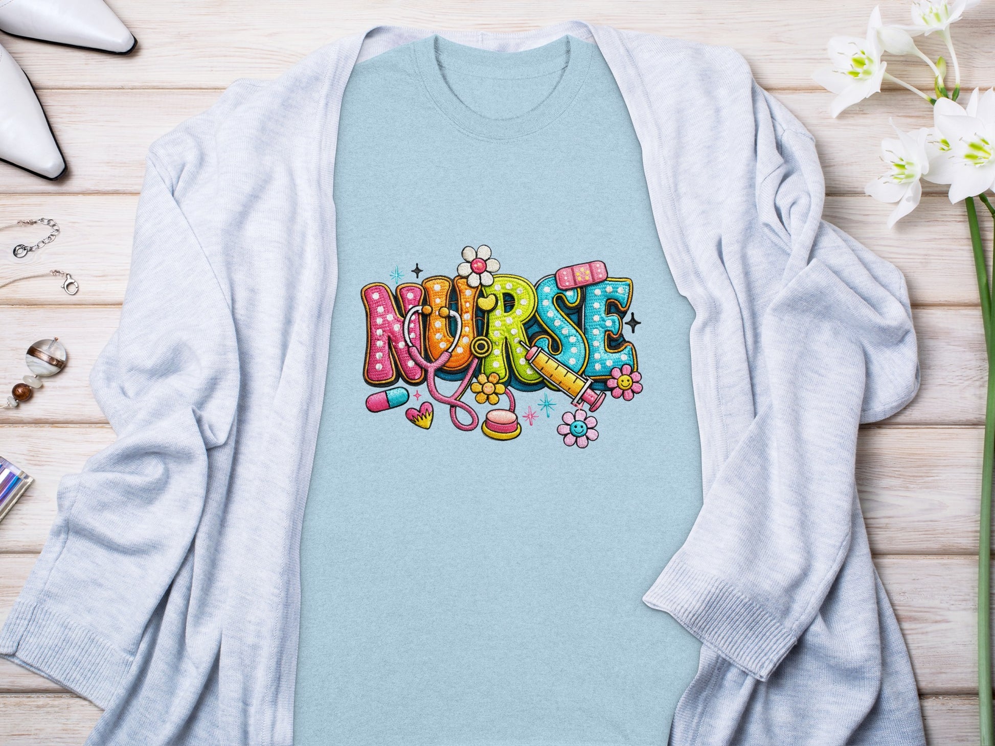 Light blue t-shirt with colorful "Nurse" text and medical icons.