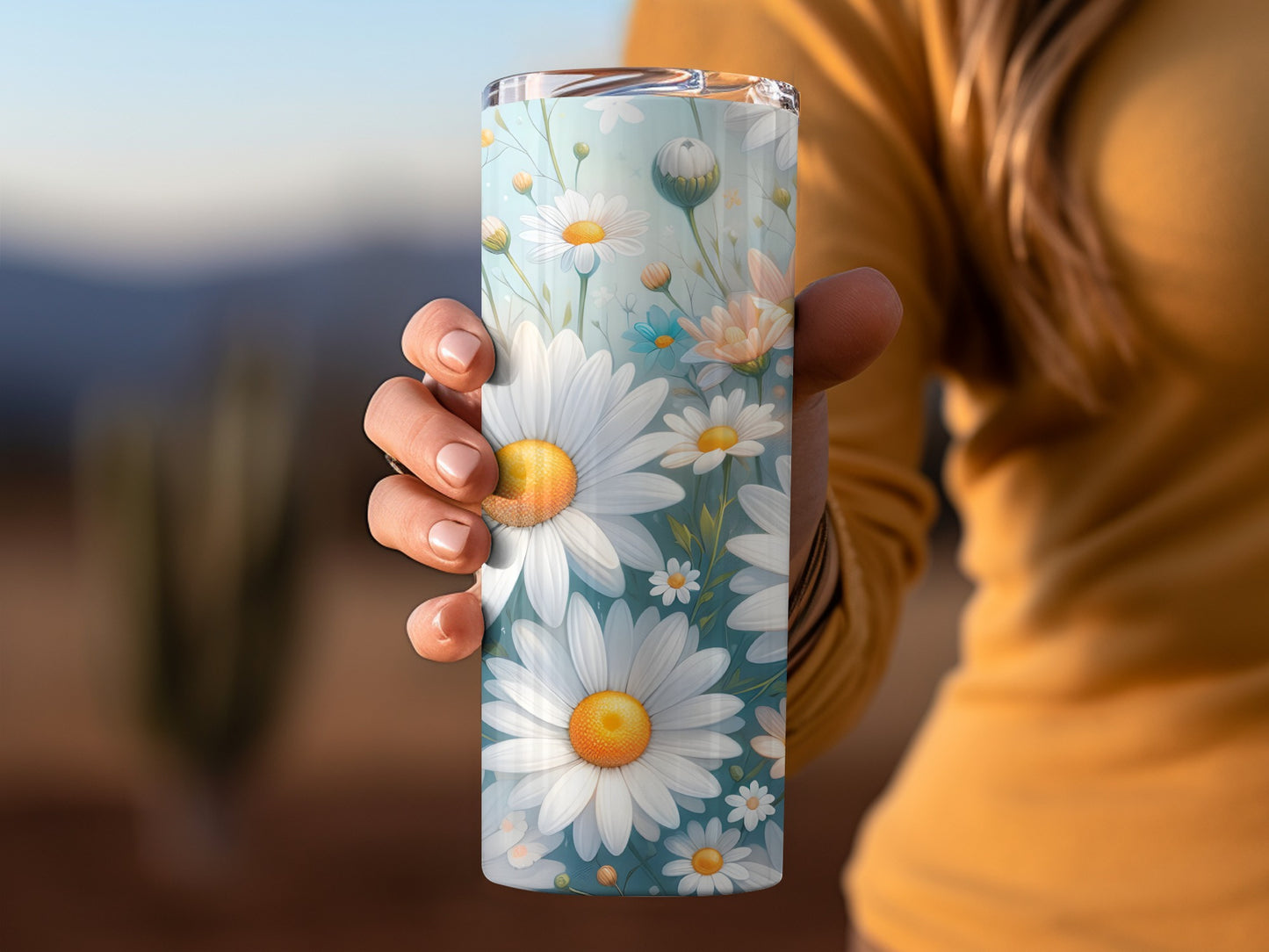 Tumbler with a floral daisy pattern and blue background.