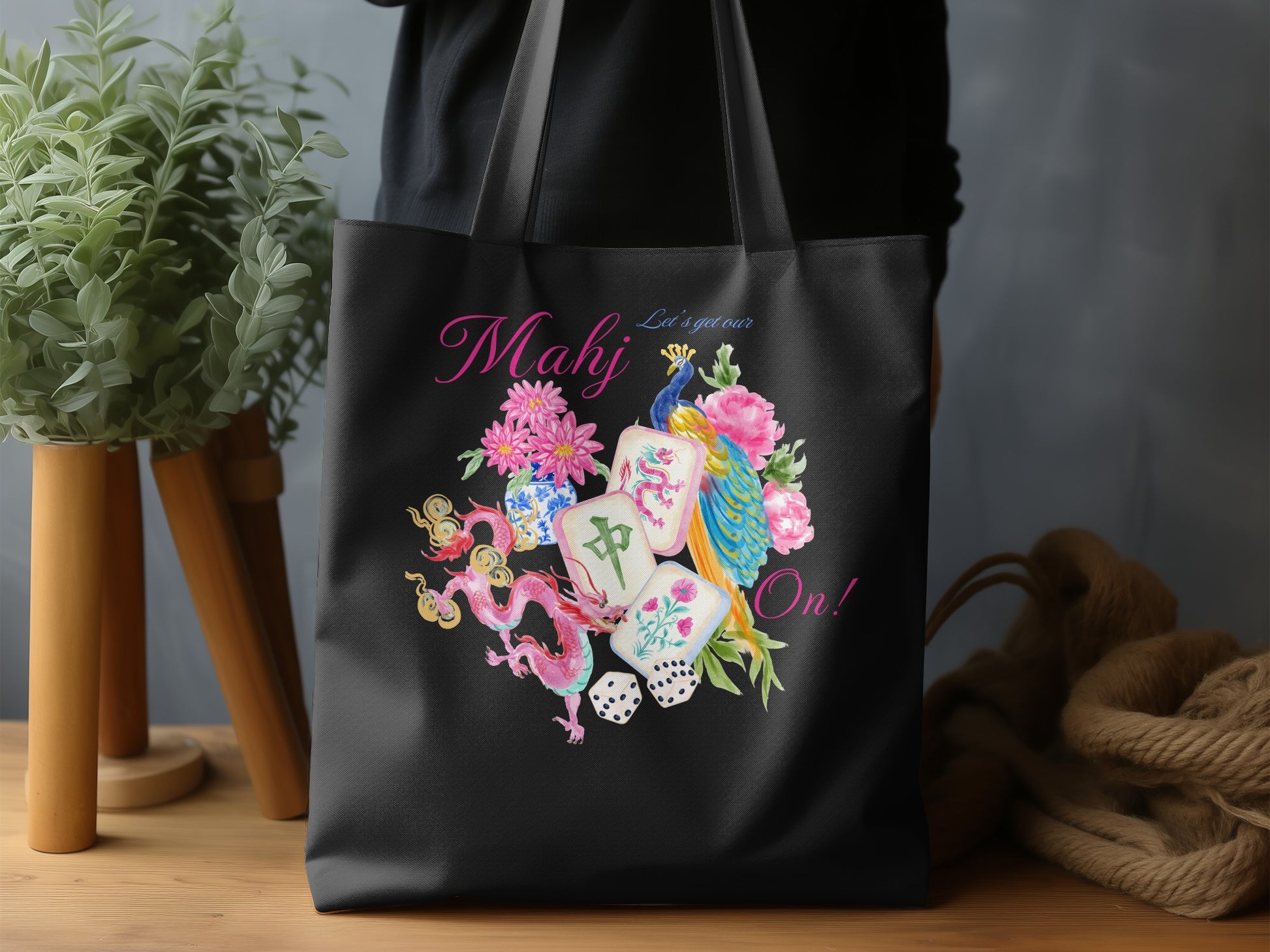 Black tote bag with "Mahj Let's get our On!" and mahjong tile design.